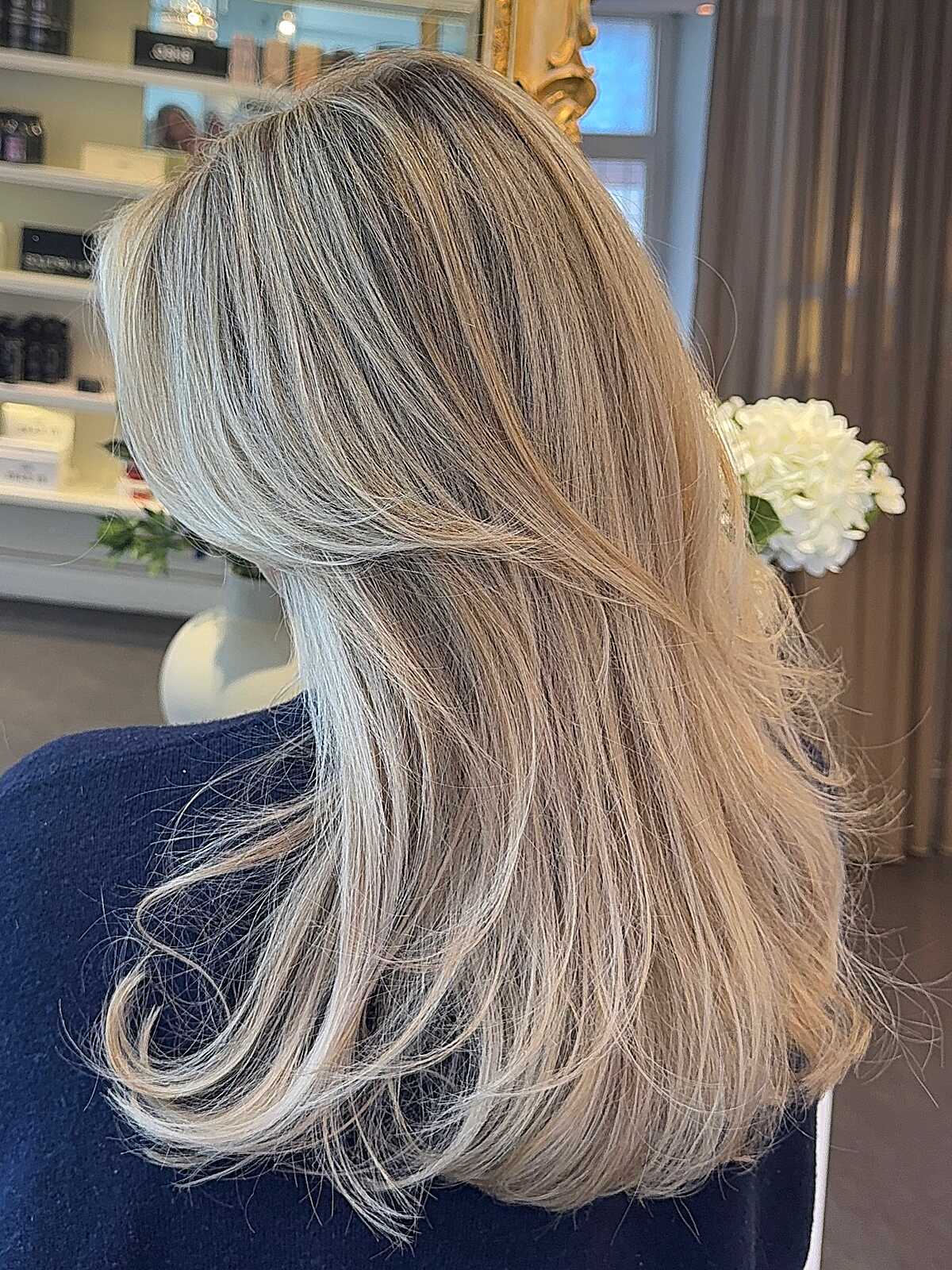 Medium layered sandy ash blonde with lived-in texture