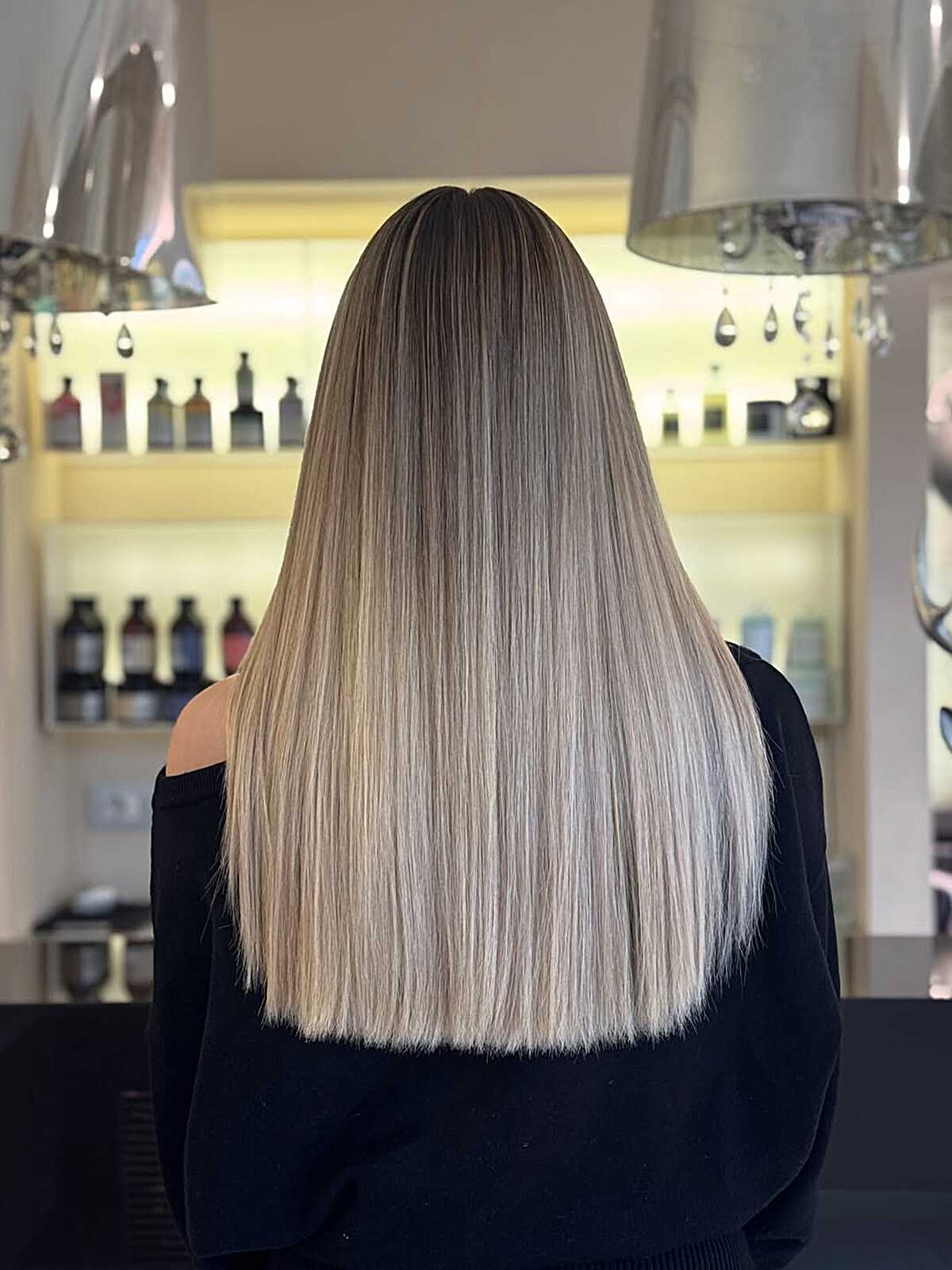 Long straight hair with dark shadow root melting to cool blonde