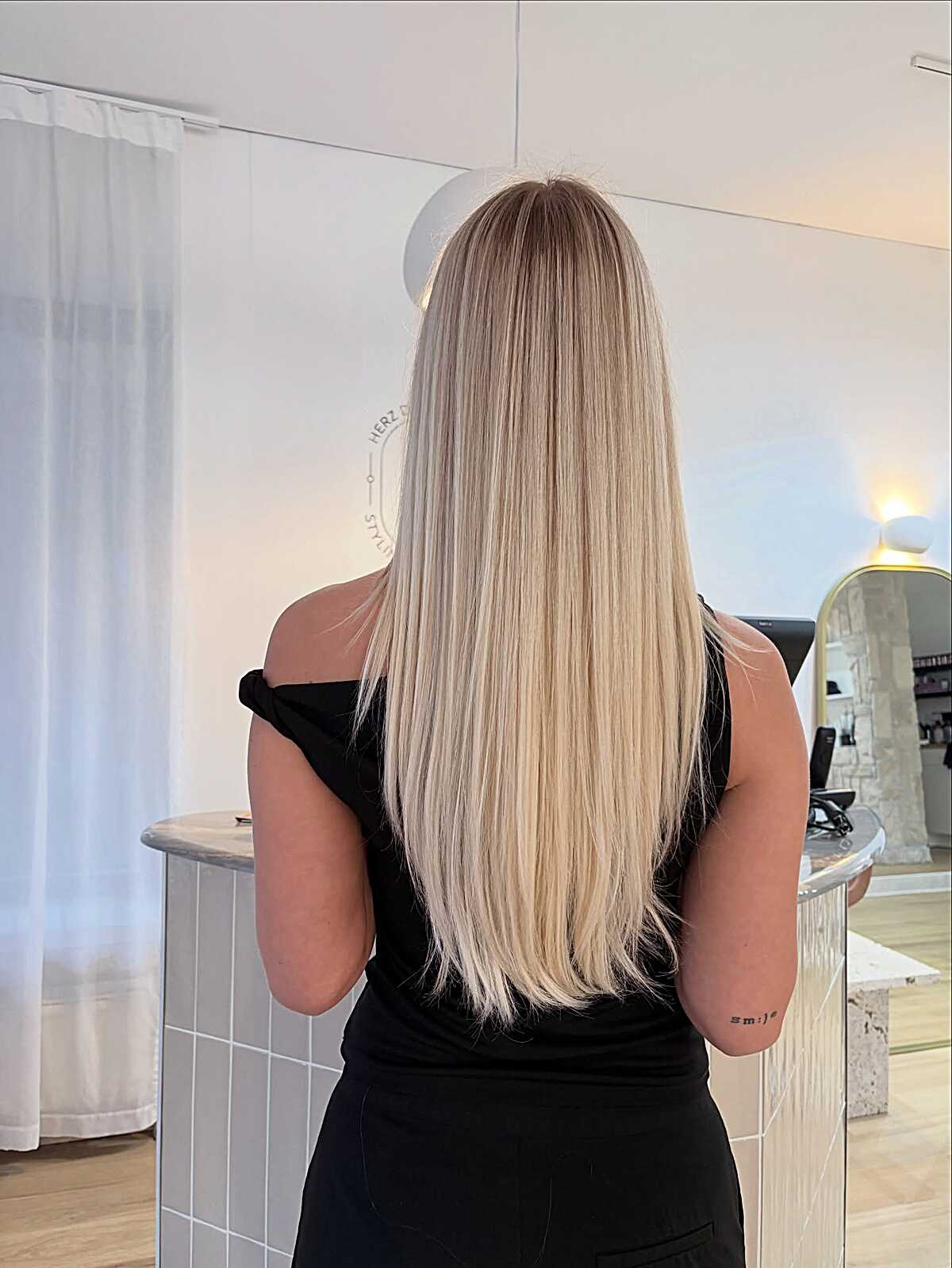 Long straight blonde with dark root melt to porcelain ends
