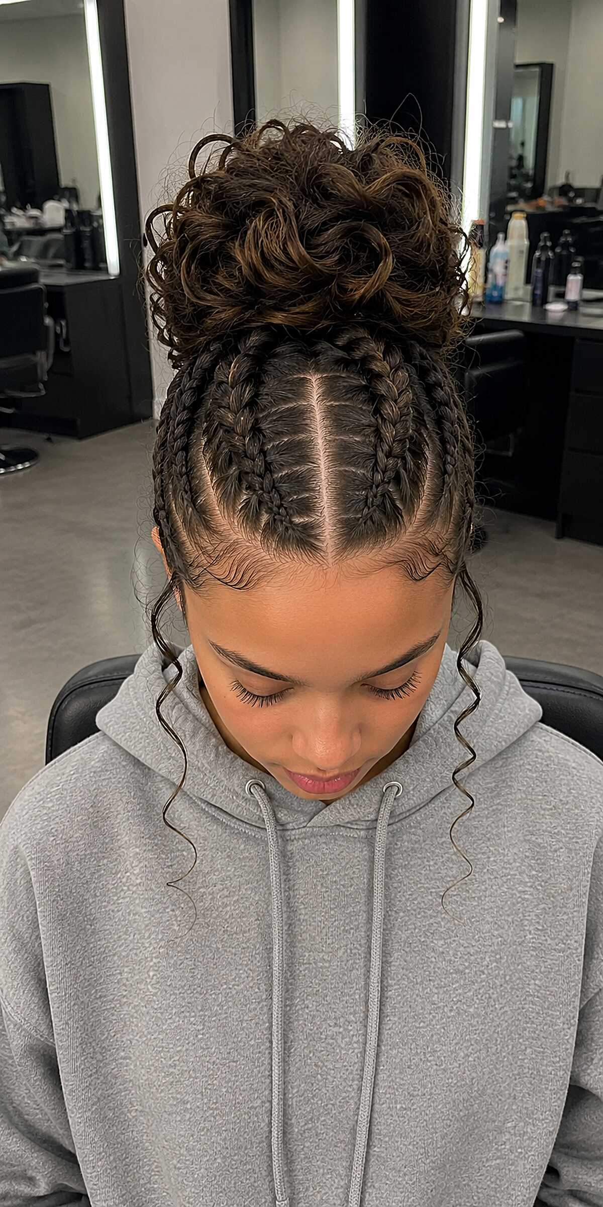 Center-Part Feed-In Cornrows with a Curly High Bun and Loose Tendrils