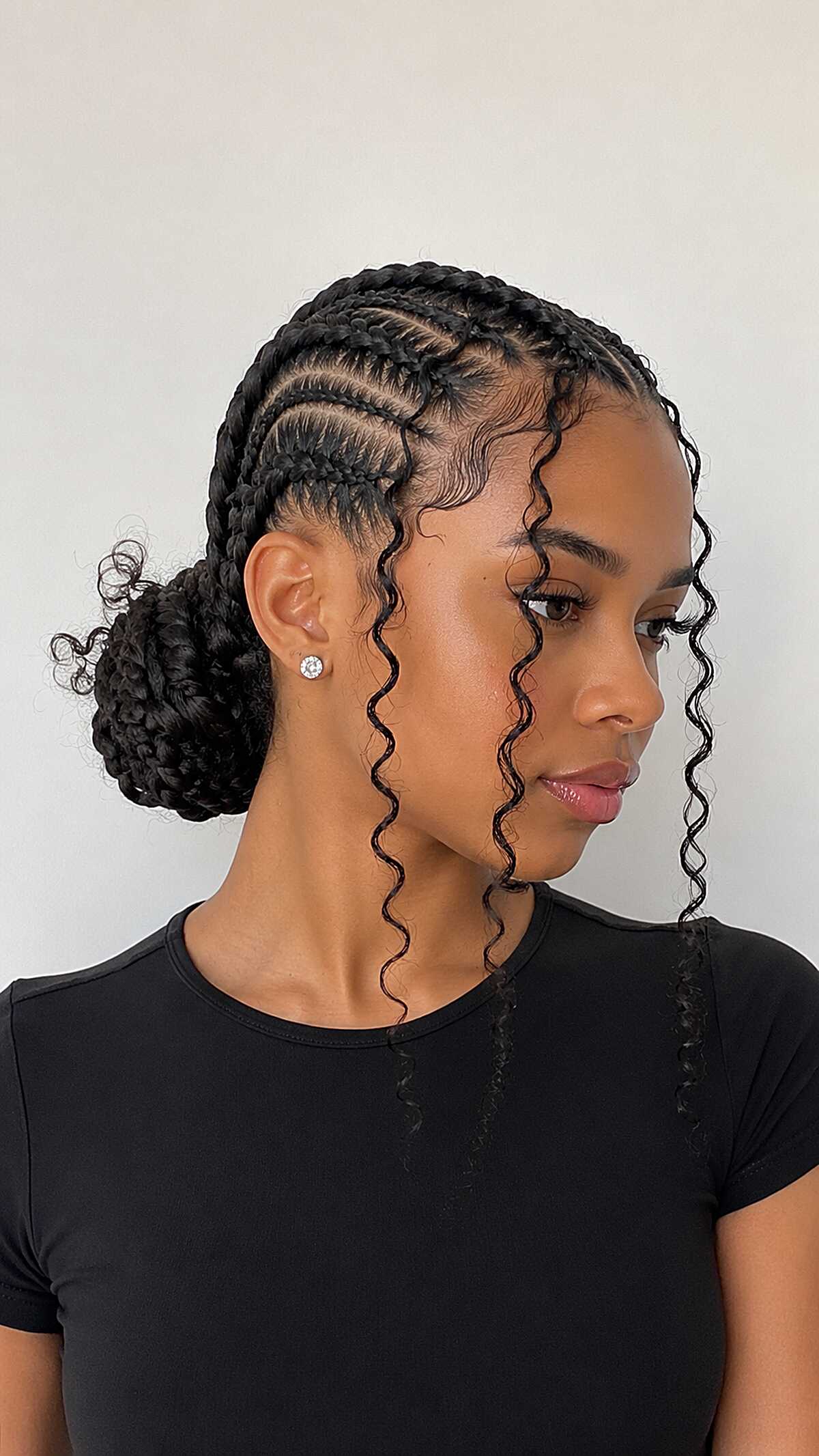 Stitch Cornrows into a Low Braided Bun with Wavy Tendrils