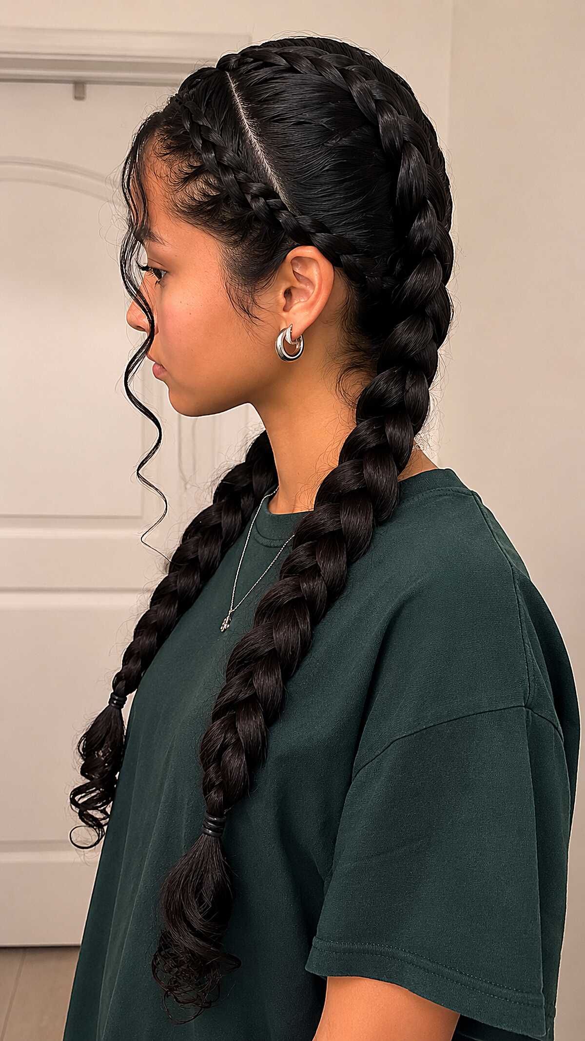 Twin Dutch Braids with Face-Framing Tendrils on Dark Hair