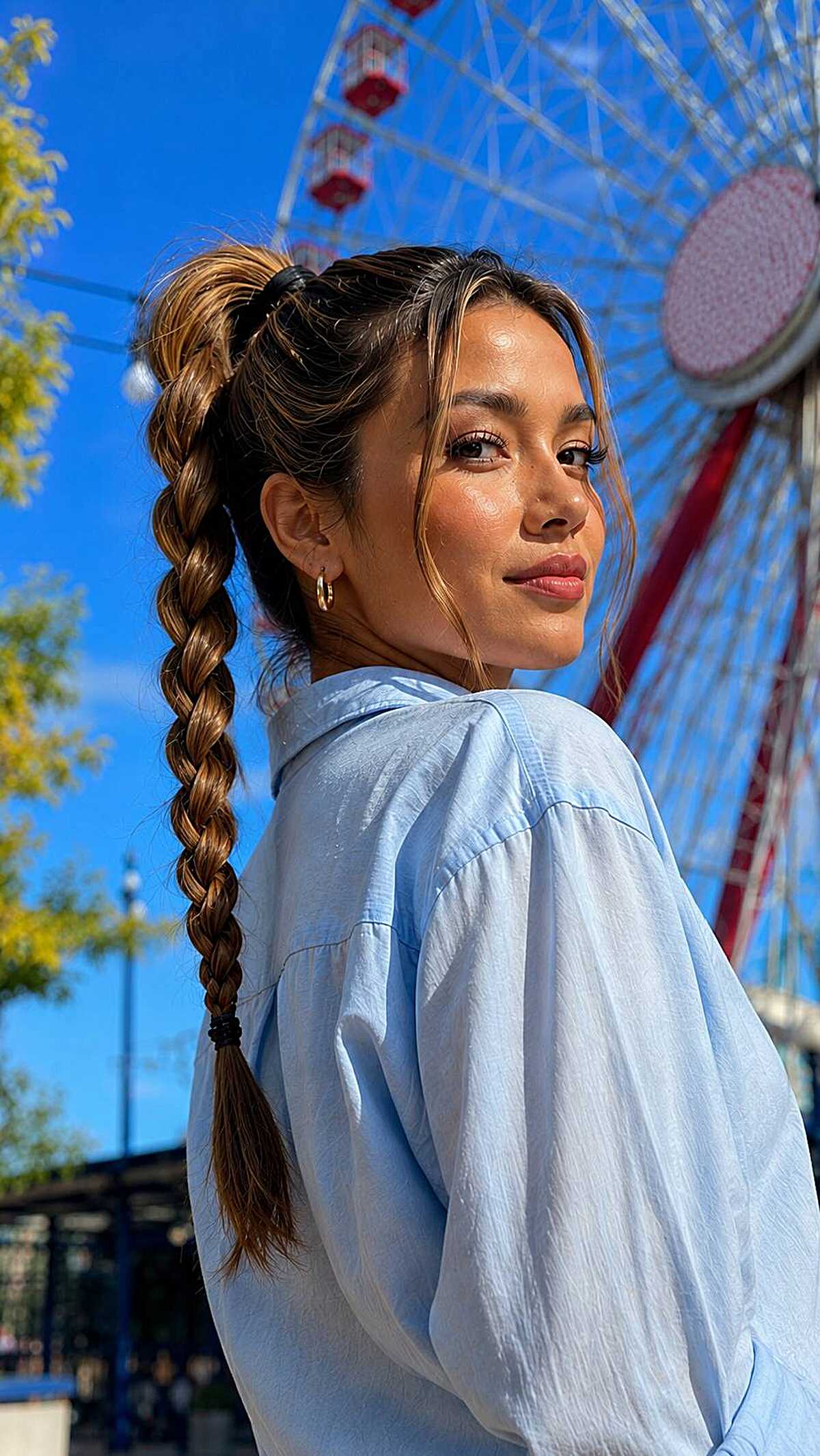 High braided ponytail with balayage highlights at a park