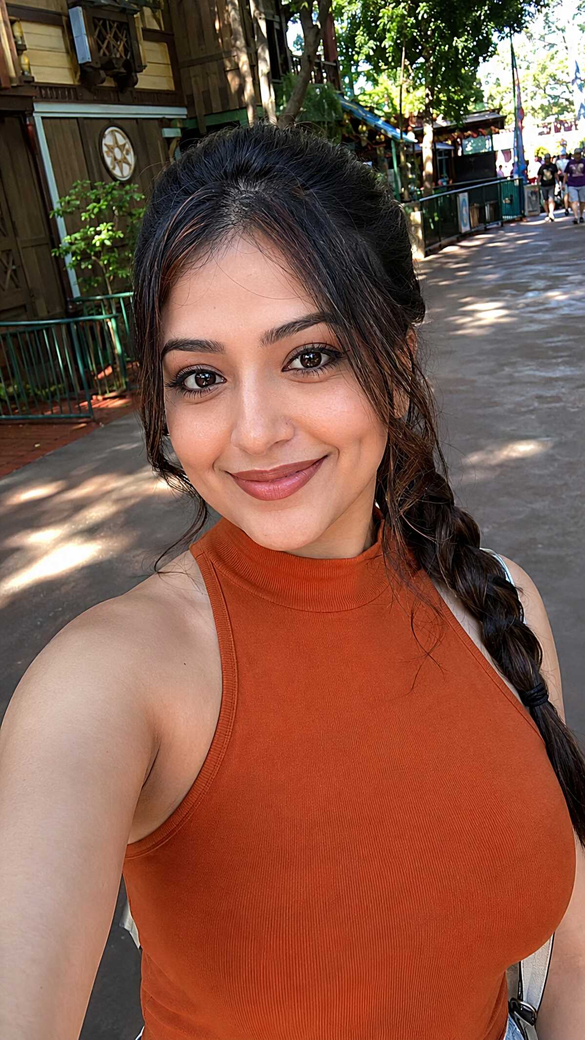 Dark hair in a low loose side braid with face-framing tendrils