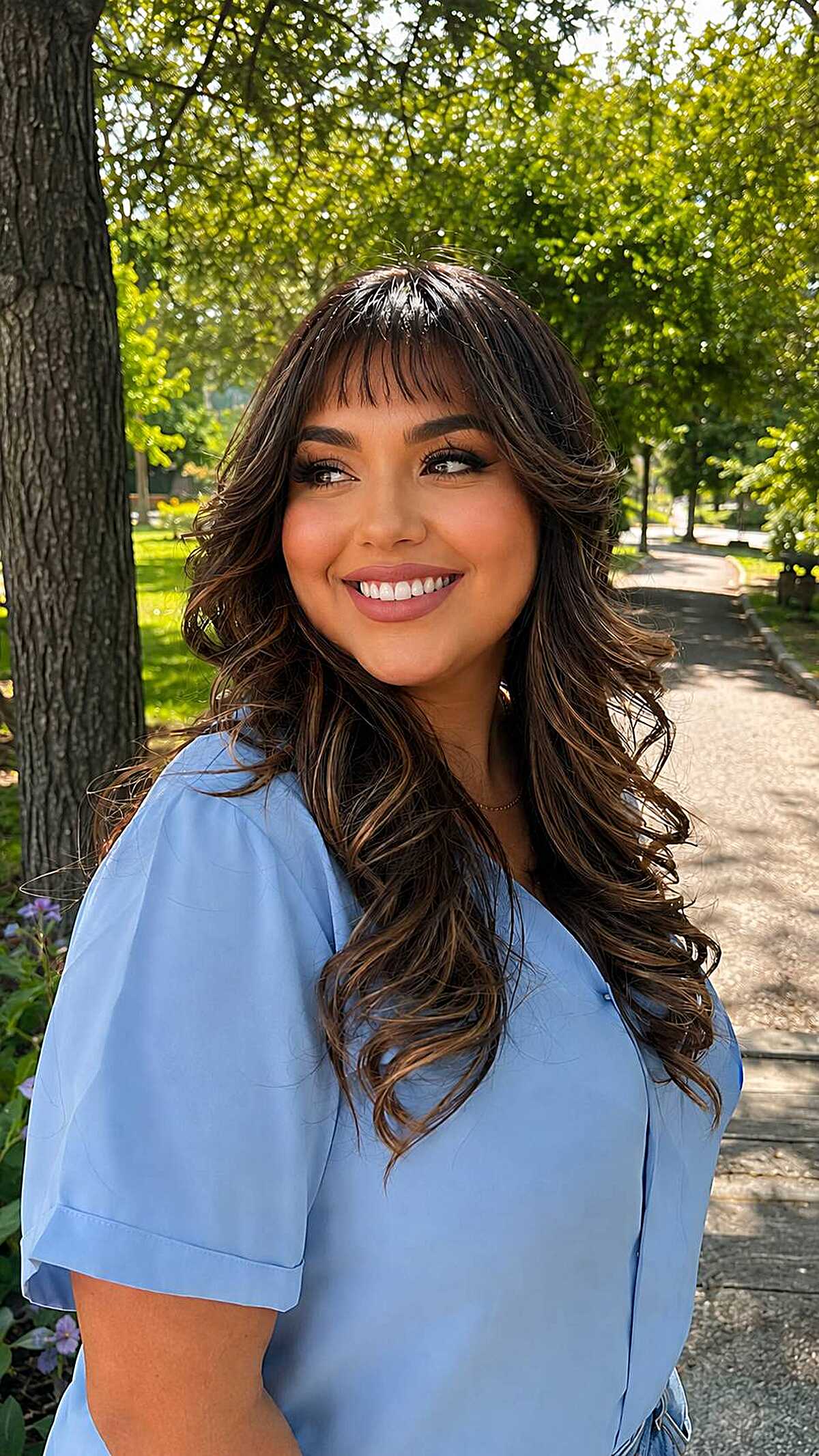 Long brunette waves with full sweeping baby bangs