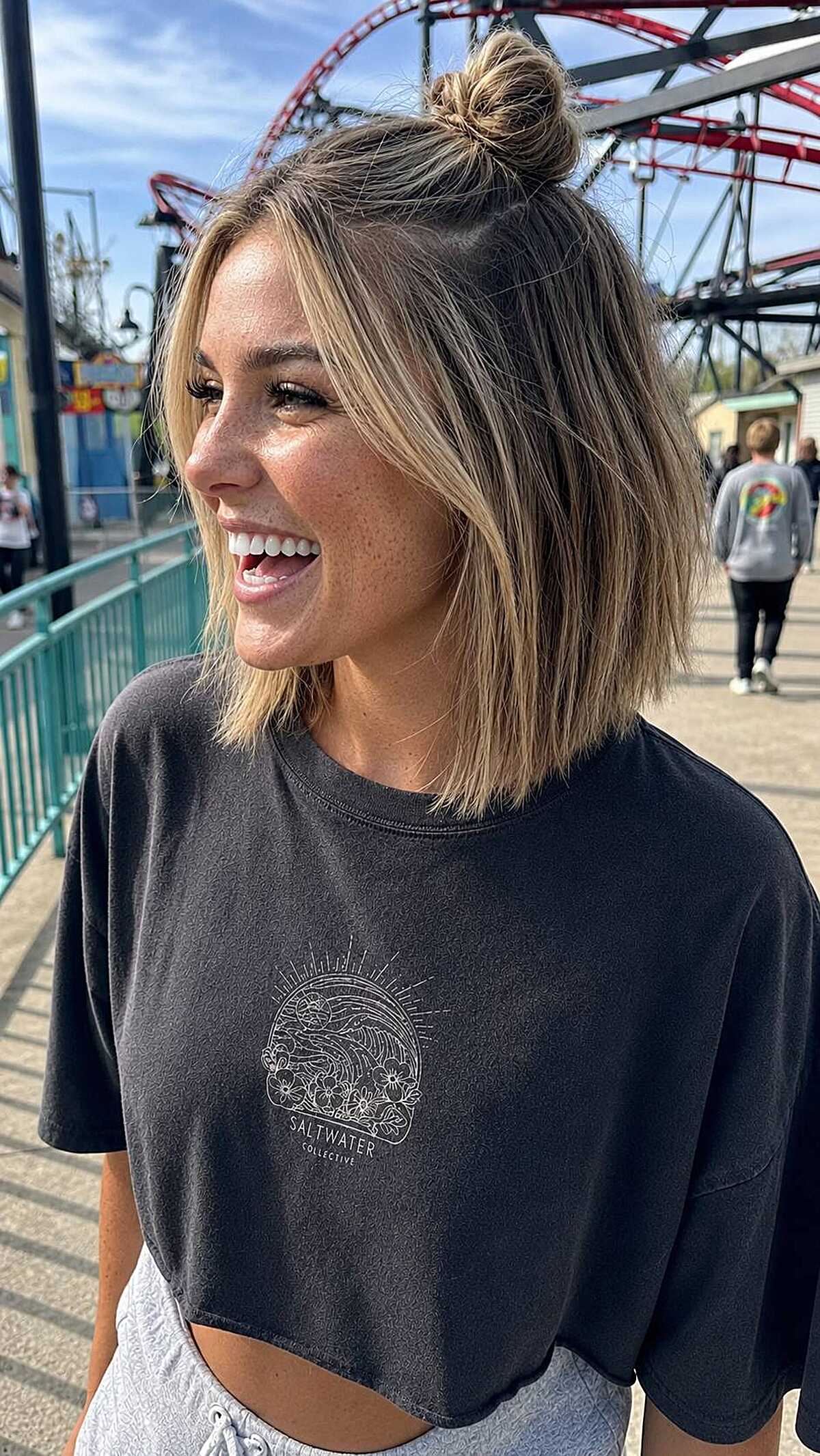 Half-up top knot on a short textured blonde bob
