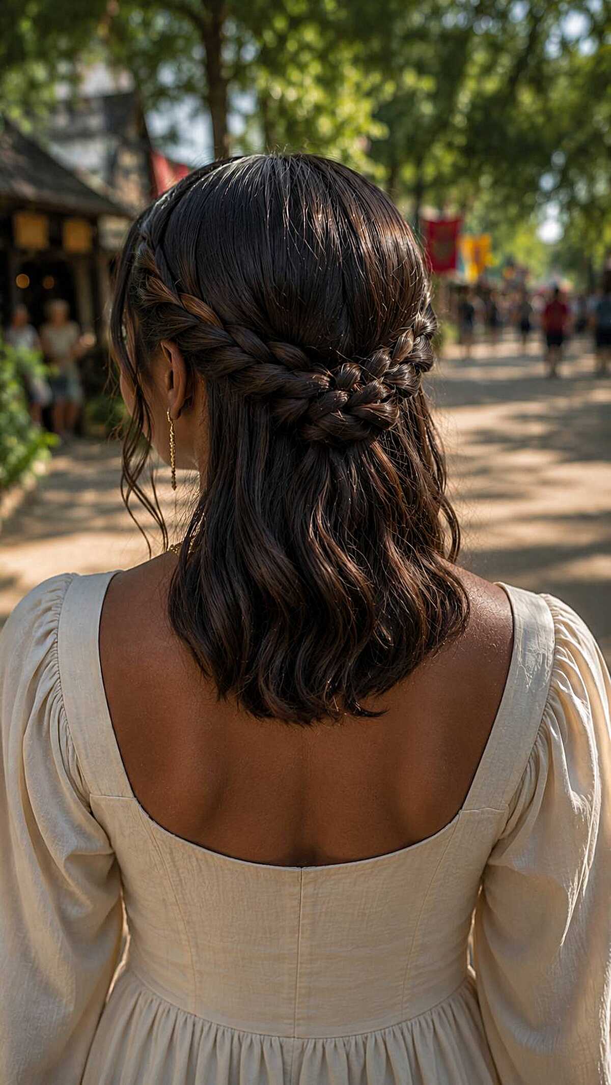 Back view of dark braided half-up style with woven knot