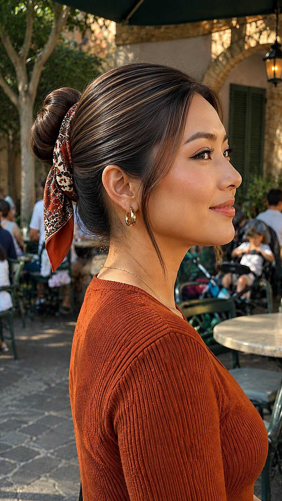 Low bun wrapped with a patterned scarf and wisps