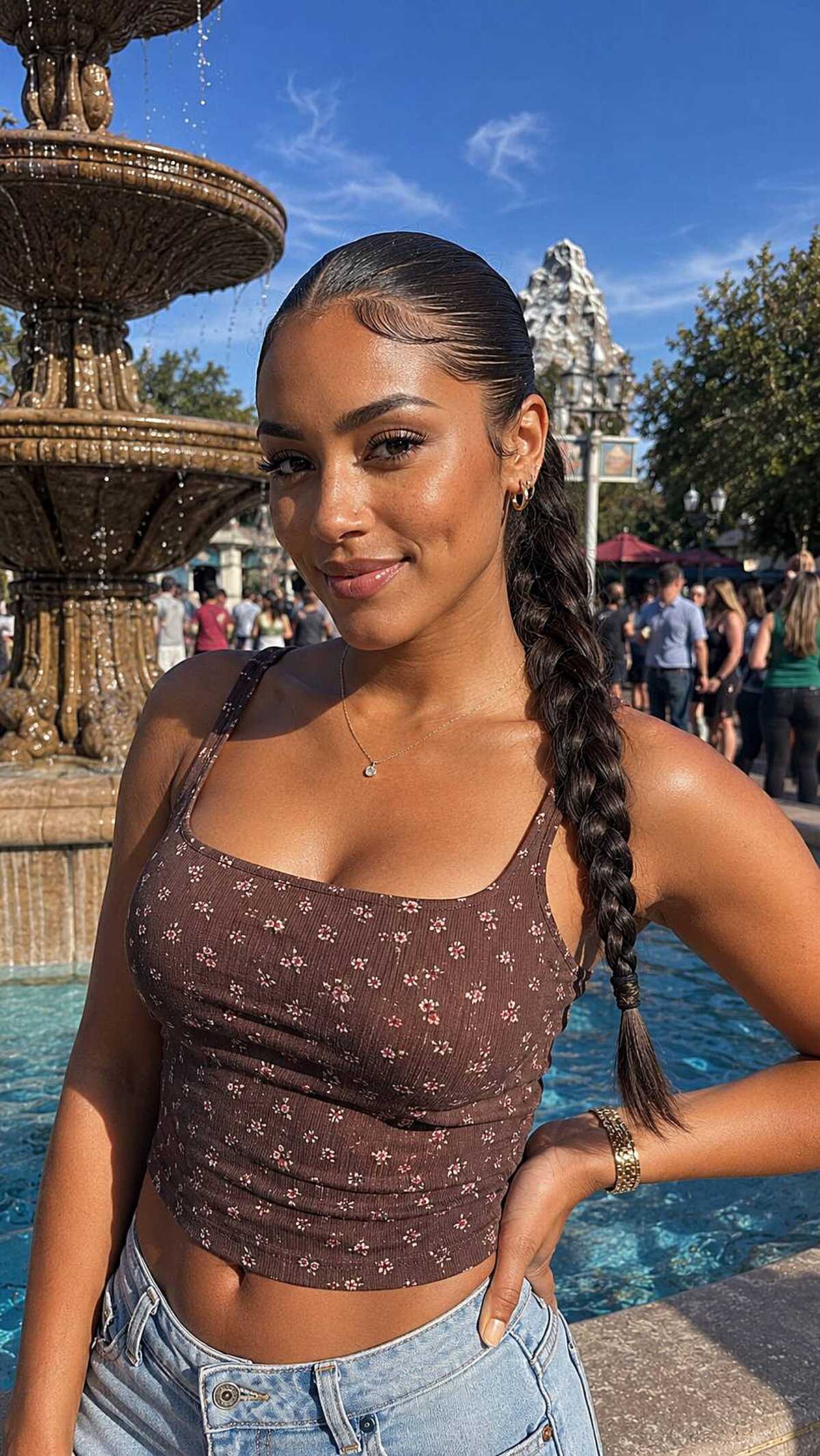 Sleek slicked-back low braid at a theme park fountain
