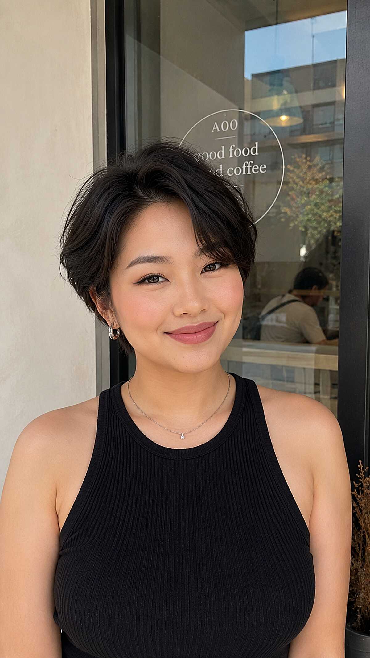 Short tousled black crop with soft texture at ear length
