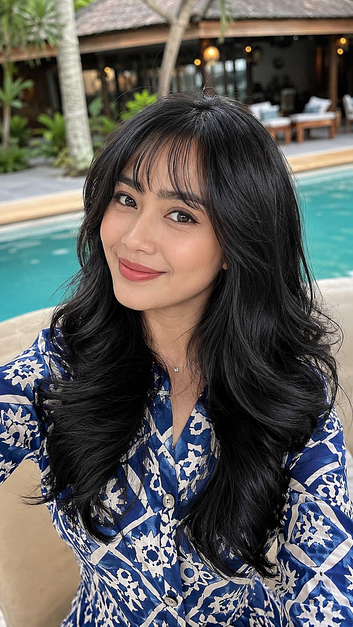 Long black layered hair with feathered bangs poolside