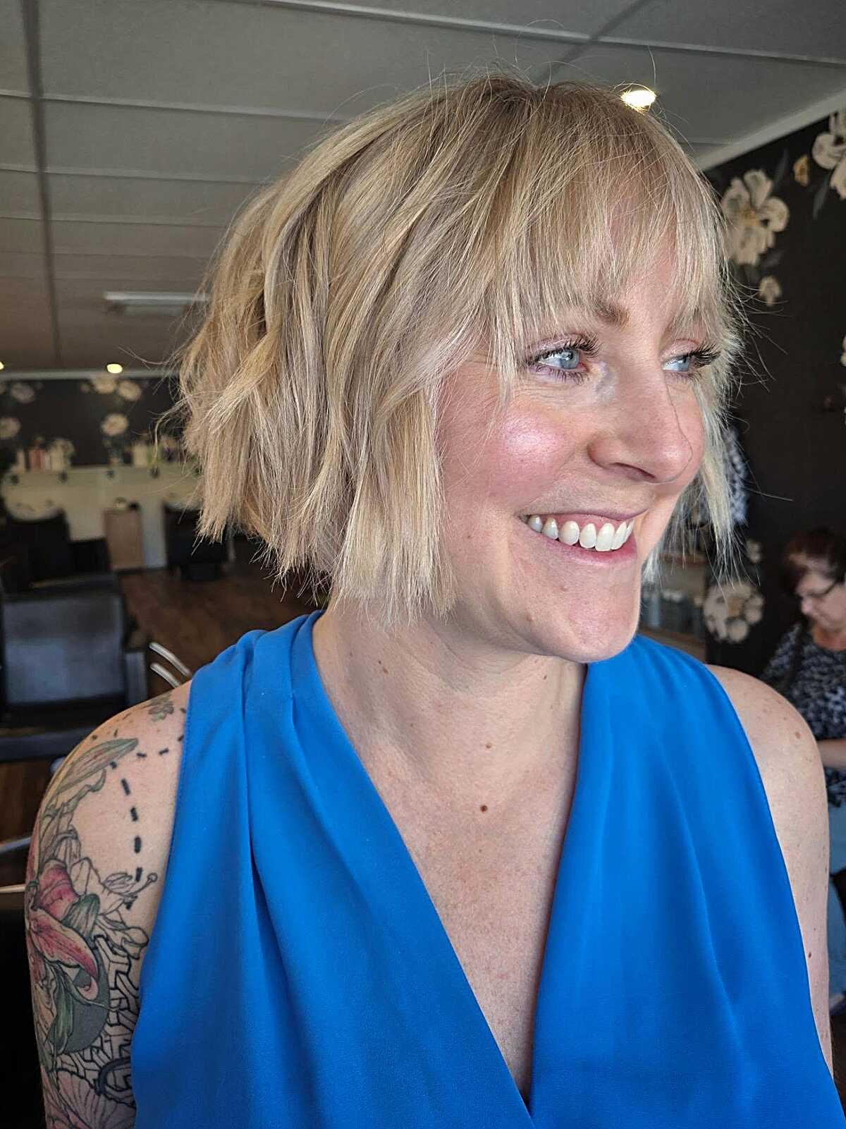 Choppy blonde bixie with wispy bangs and textured ends