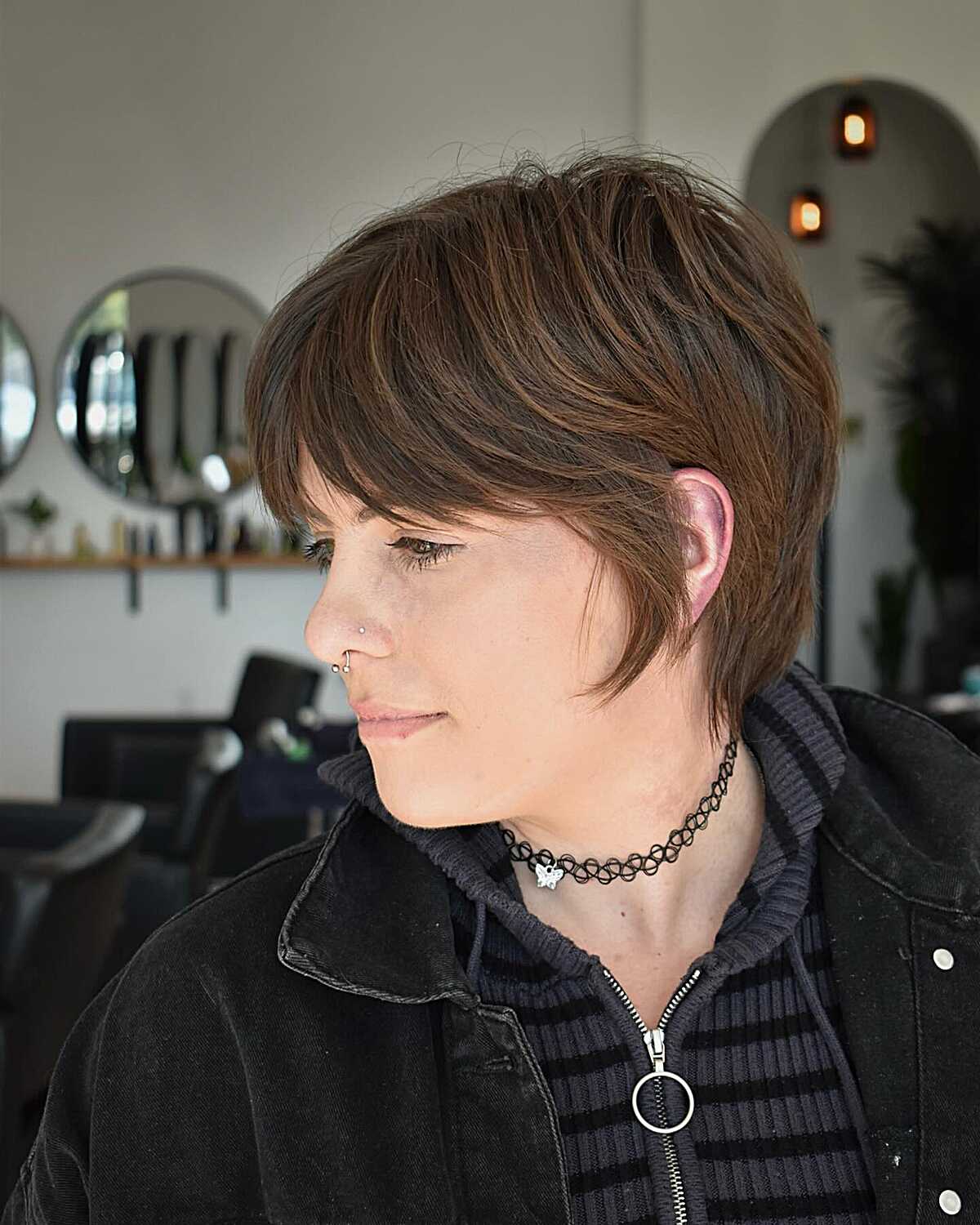 Brunette 90s grunge bixie with choppy bangs and layers