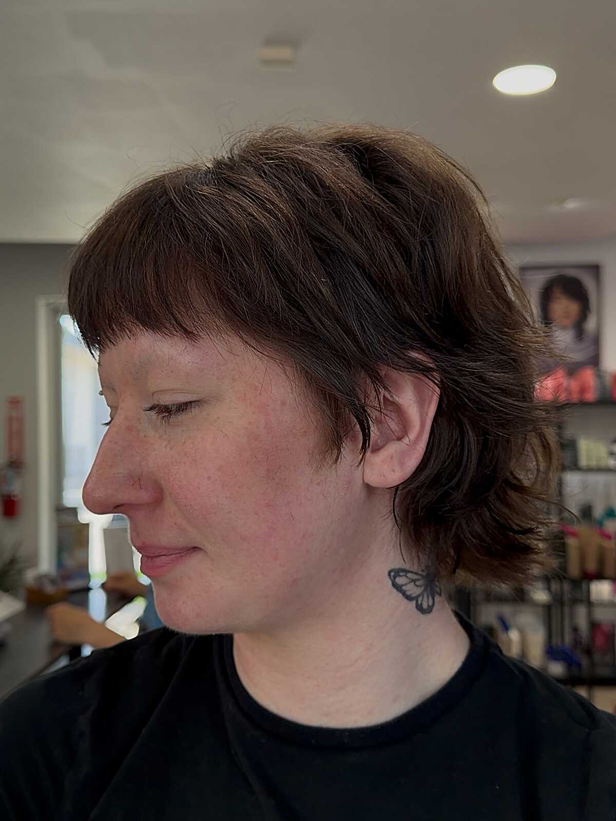 Warm brown bixie mullet with choppy bangs and layers
