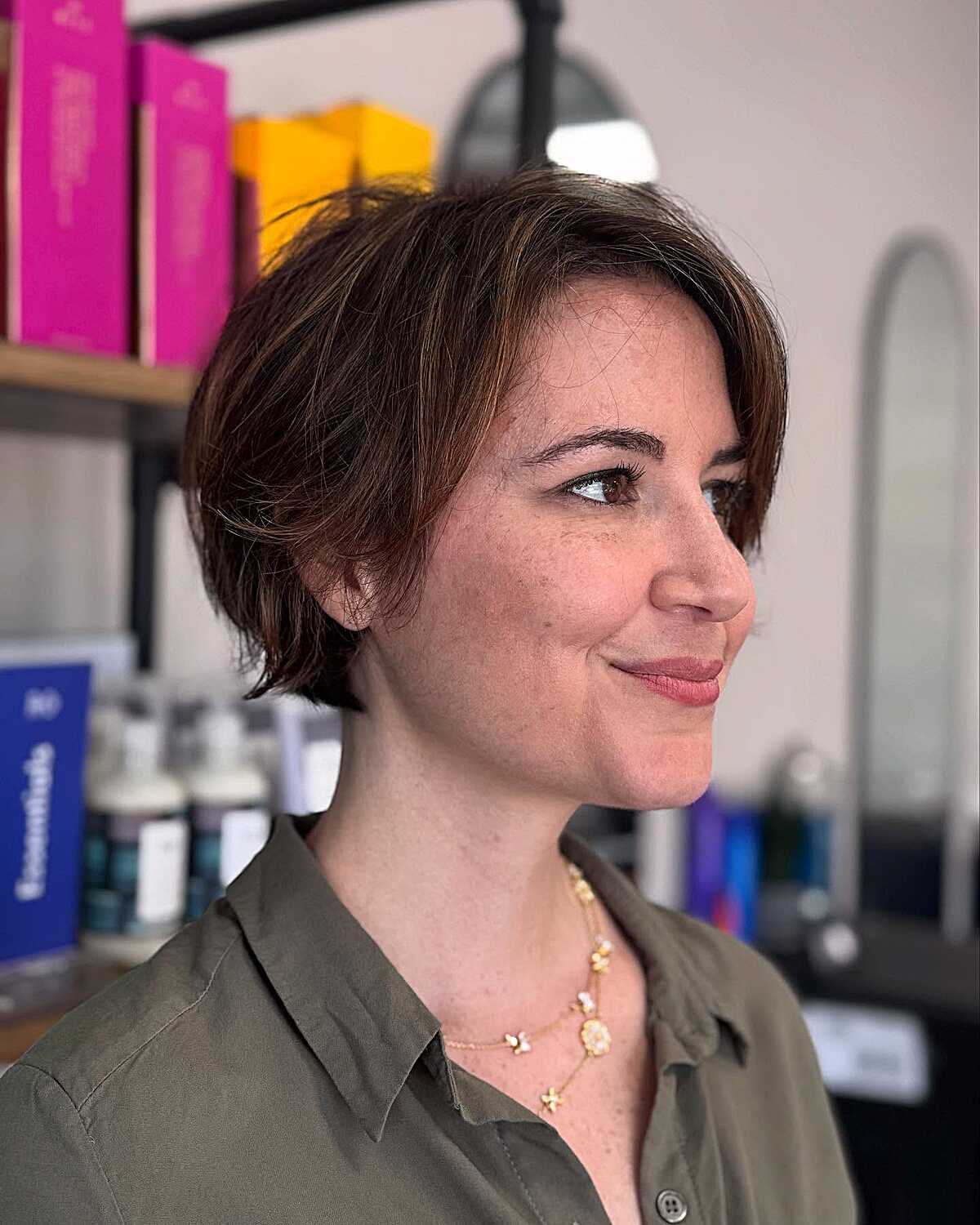 Warm brunette bixie with deep side part and subtle highlights