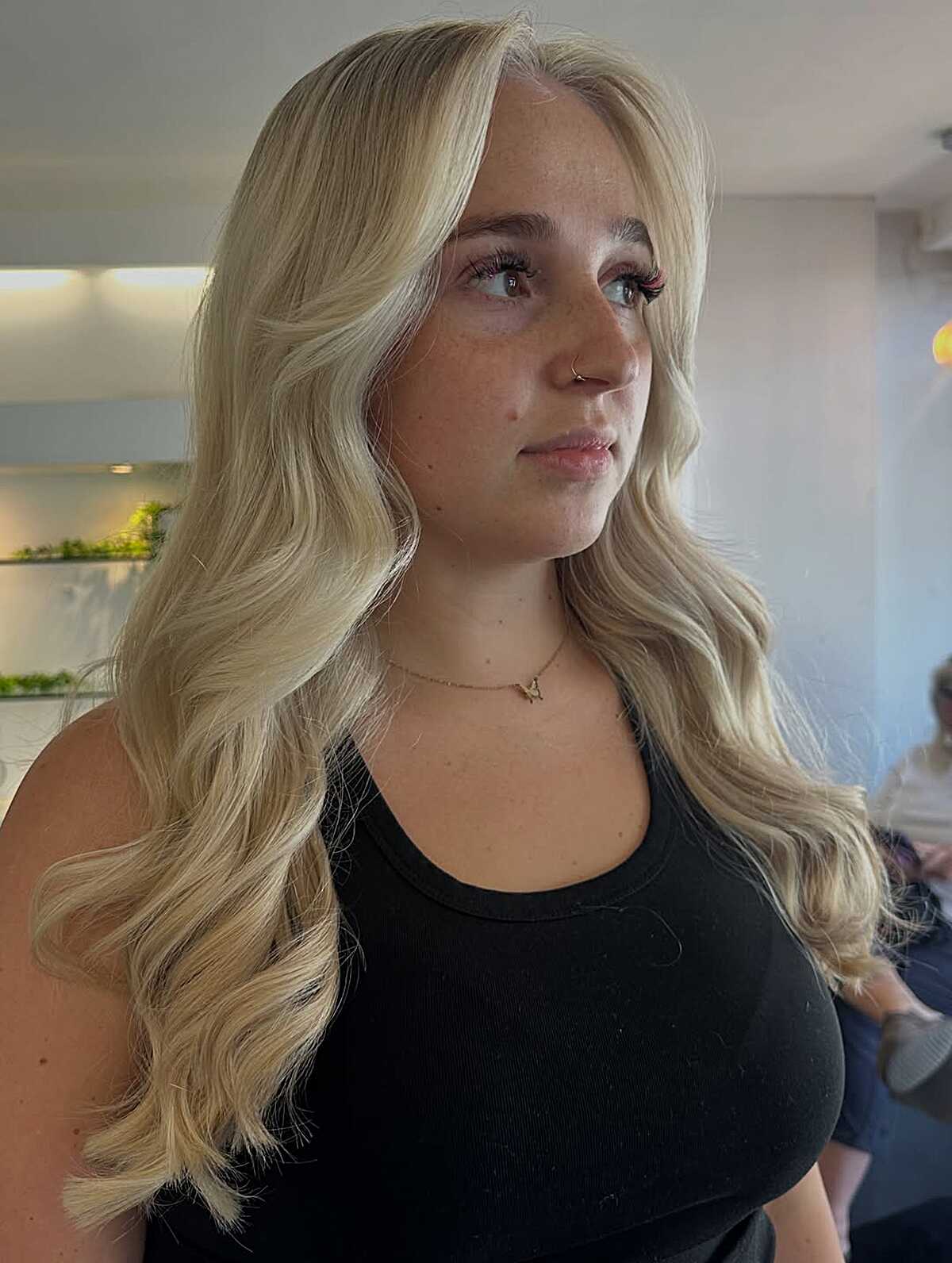 Long bright champagne blonde waves with a deep side part