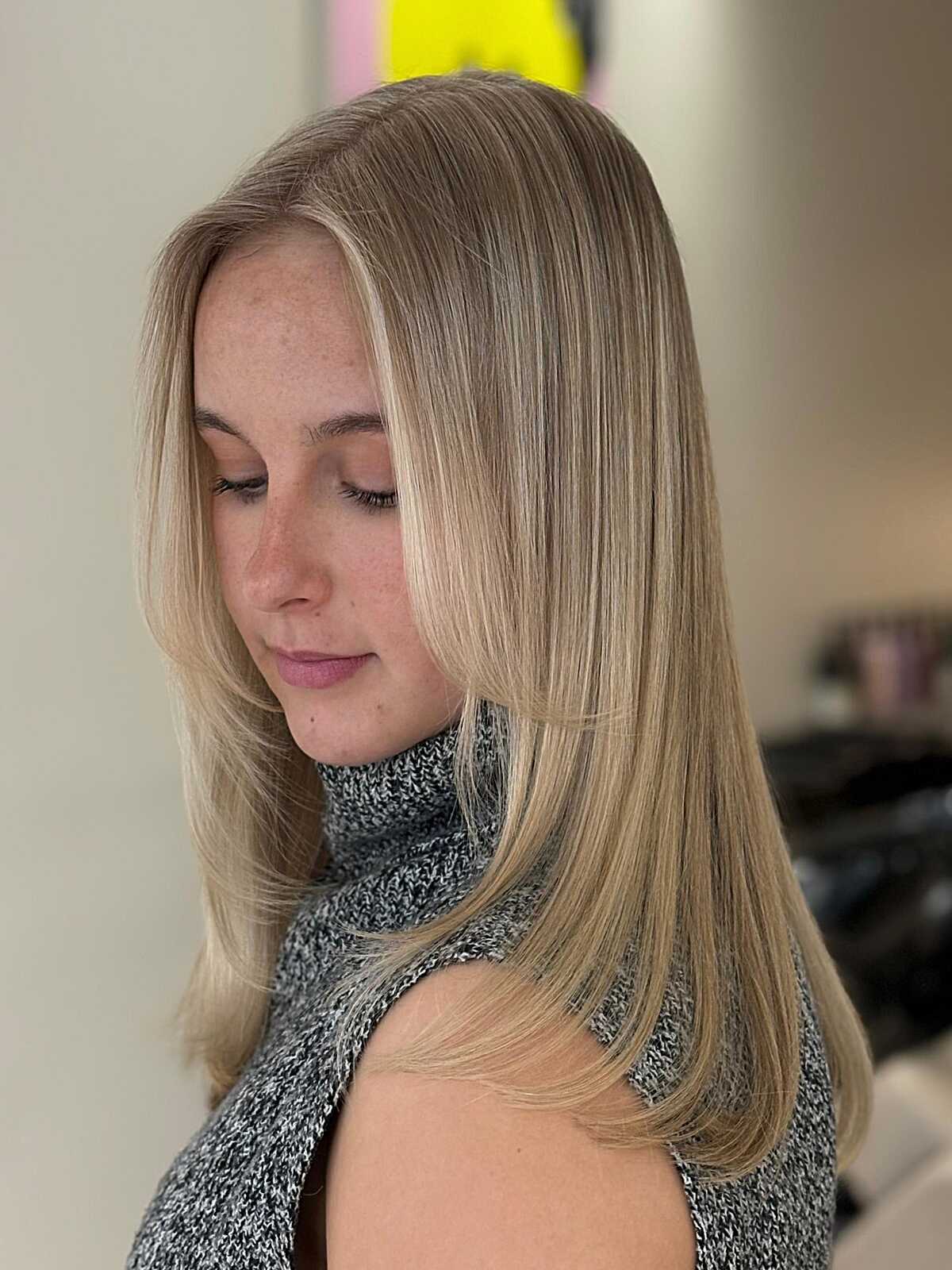 Sleek medium-length ash blonde hair with subtle layers