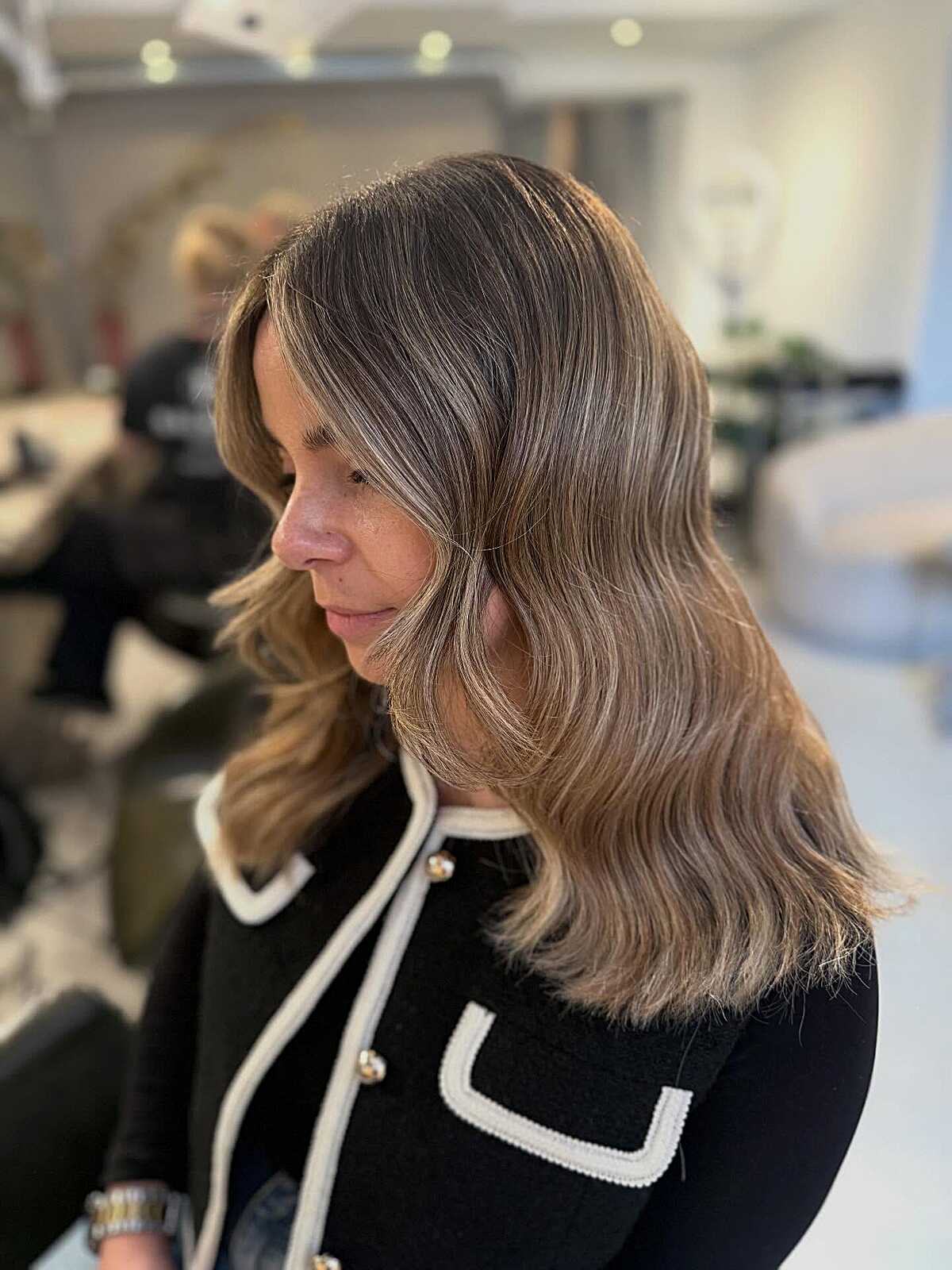Warm ash blonde shoulder-length hair with soft layers
