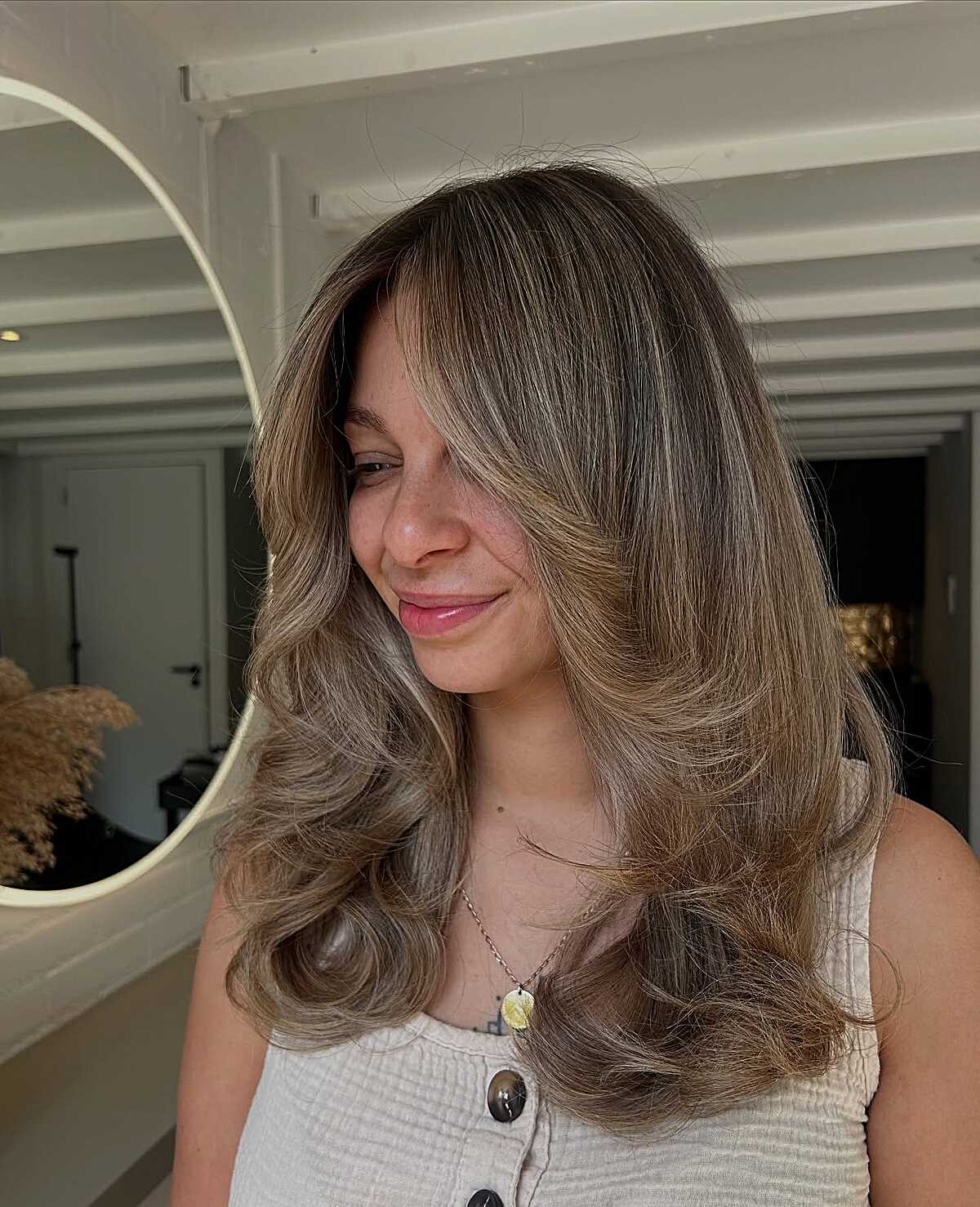 Warm brunette long hair with curtain layers and curled ends