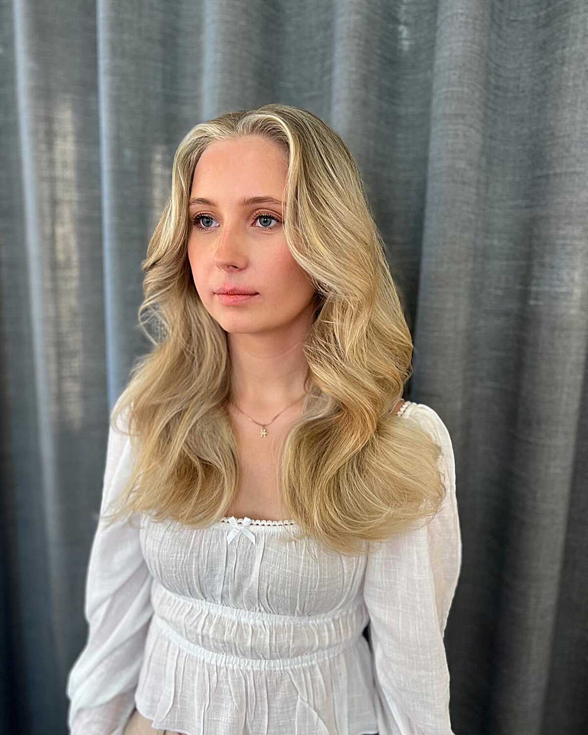 Warm golden blonde long layers with soft curtain waves