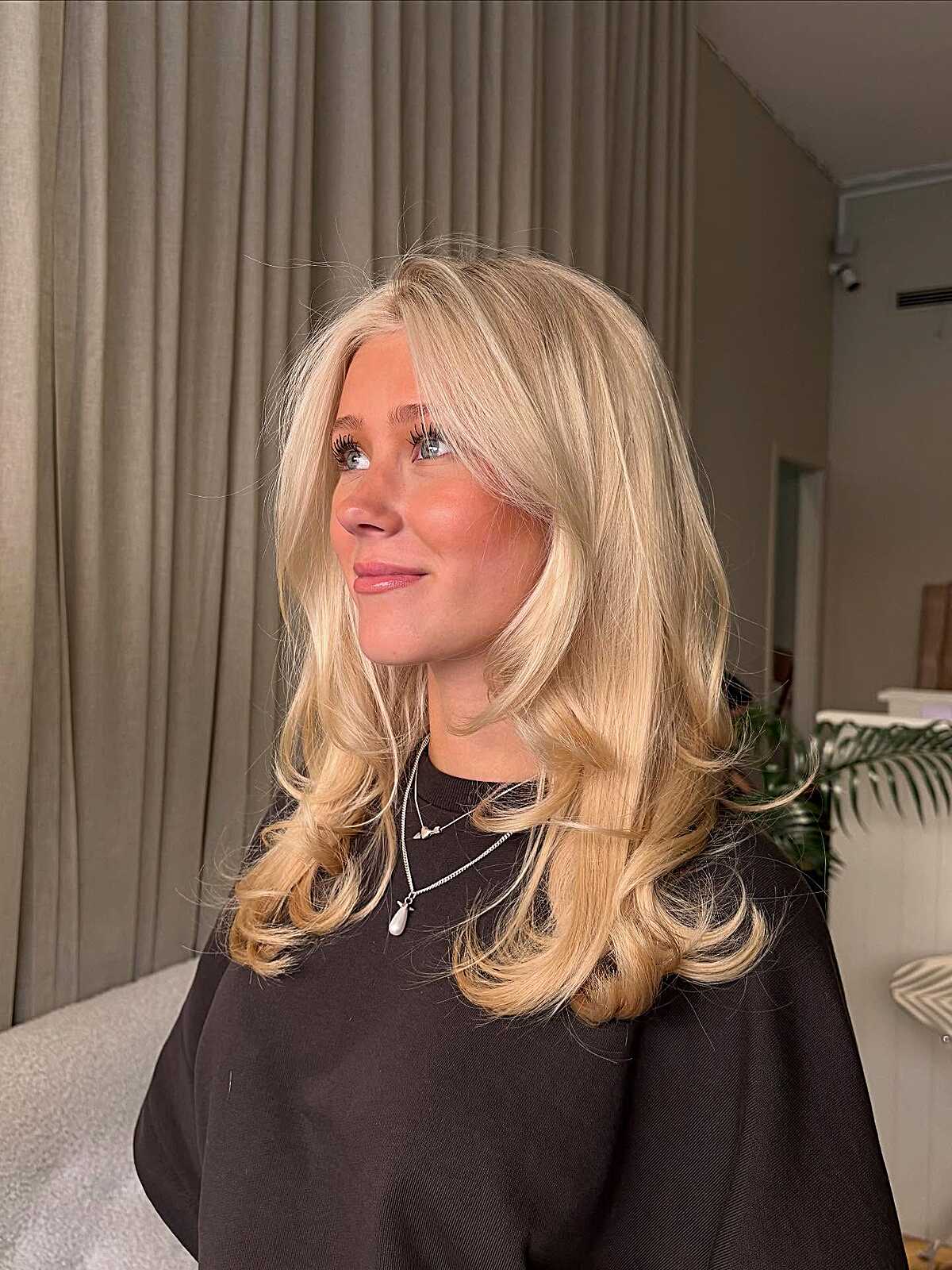 Medium blonde shoulder-length layers with flipped ends