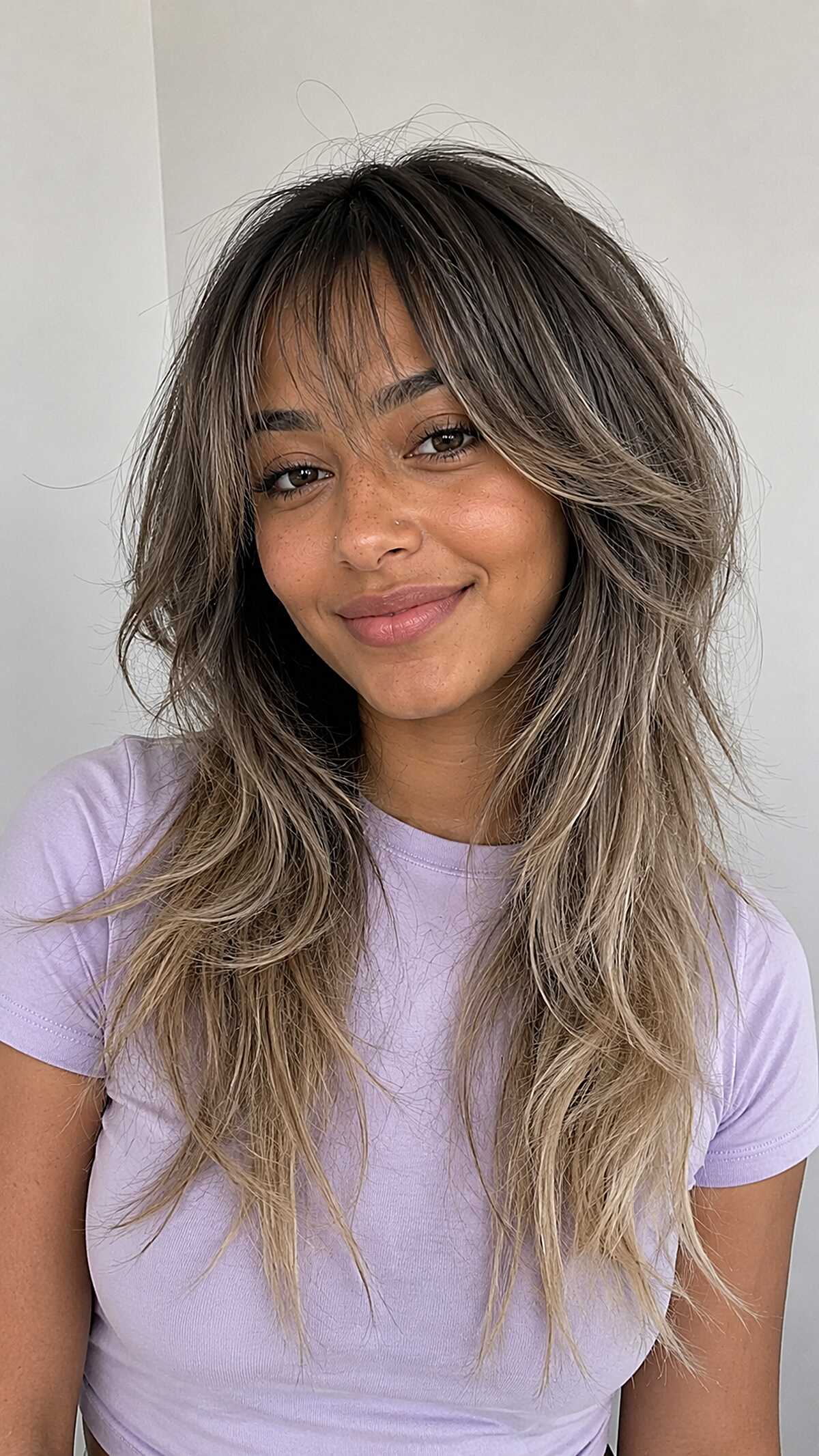 Shaggy Ash Blonde Balayage with Wispy Bangs on Warm Skin