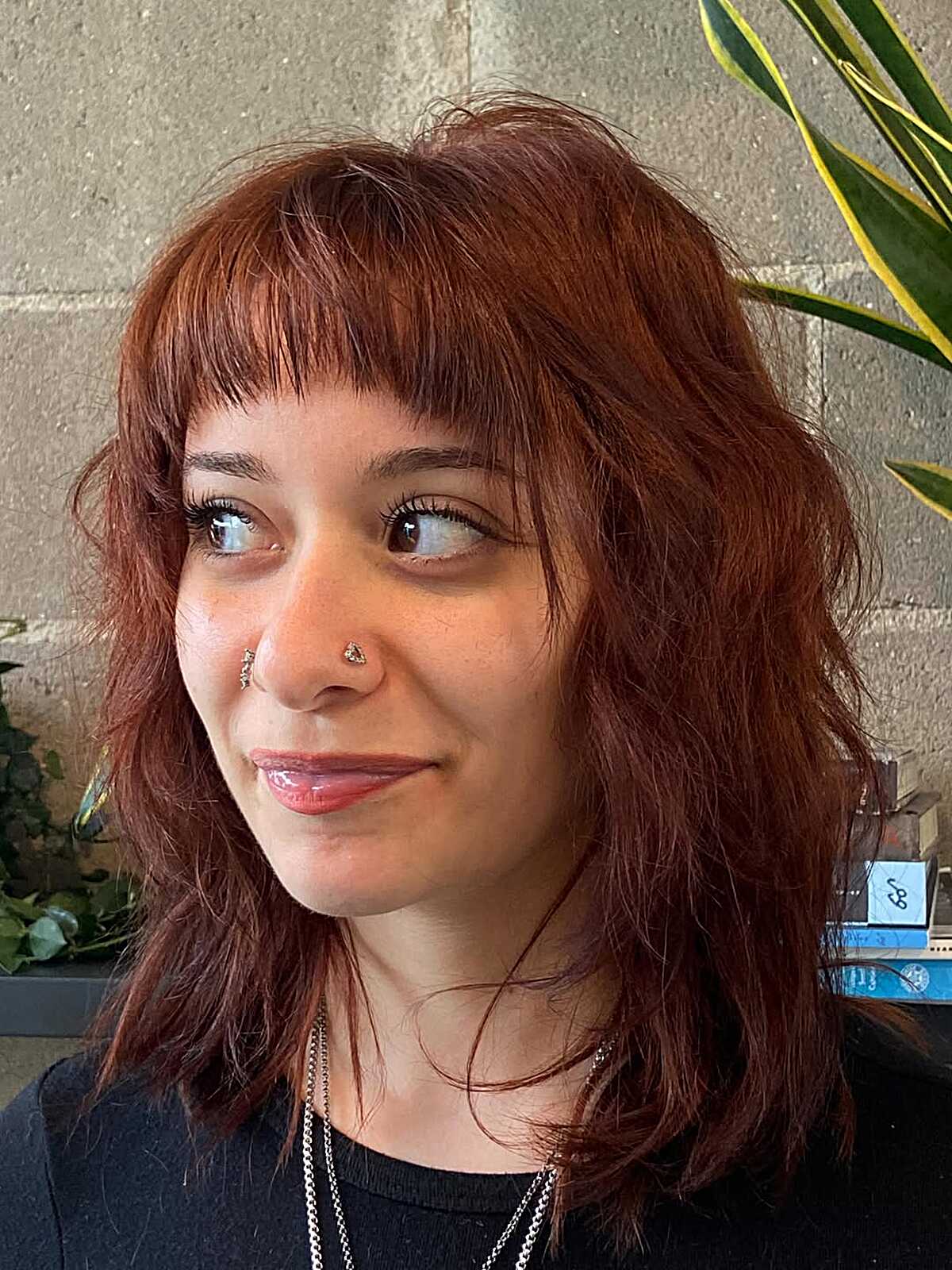Shoulder-length auburn shag with textured curtain bangs