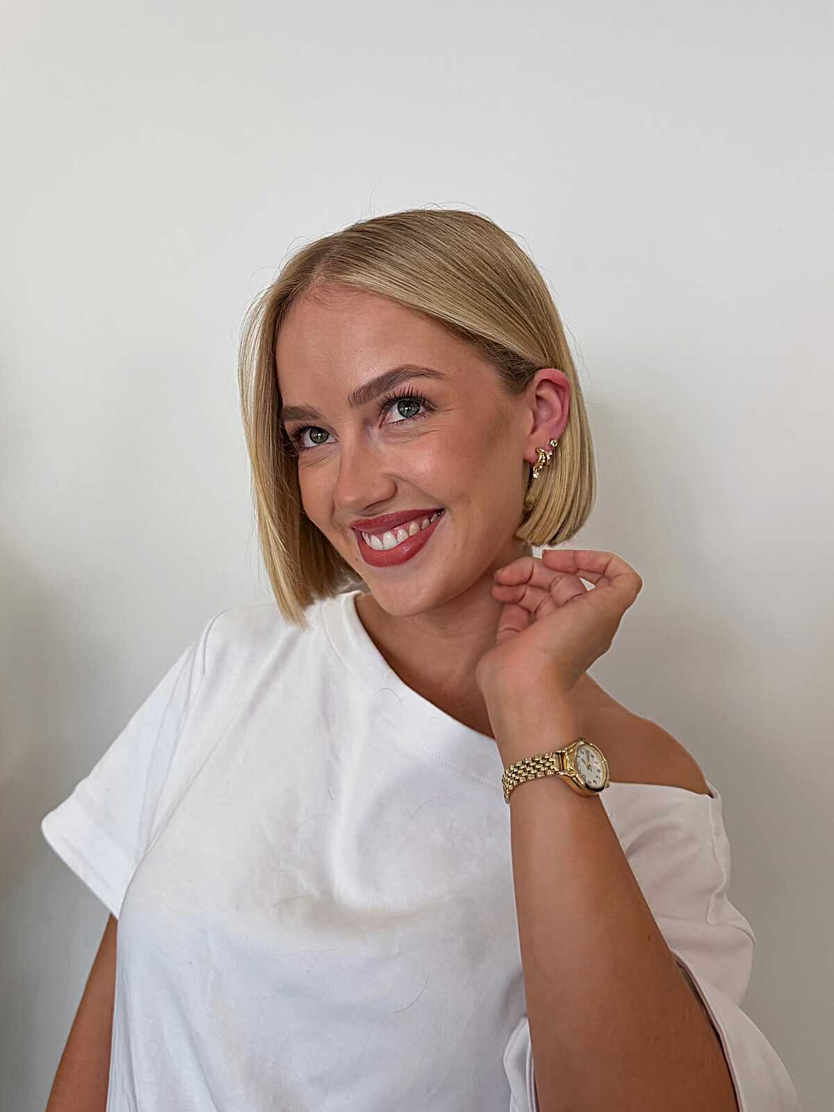 Sleek warm blonde chin-length bob with side part