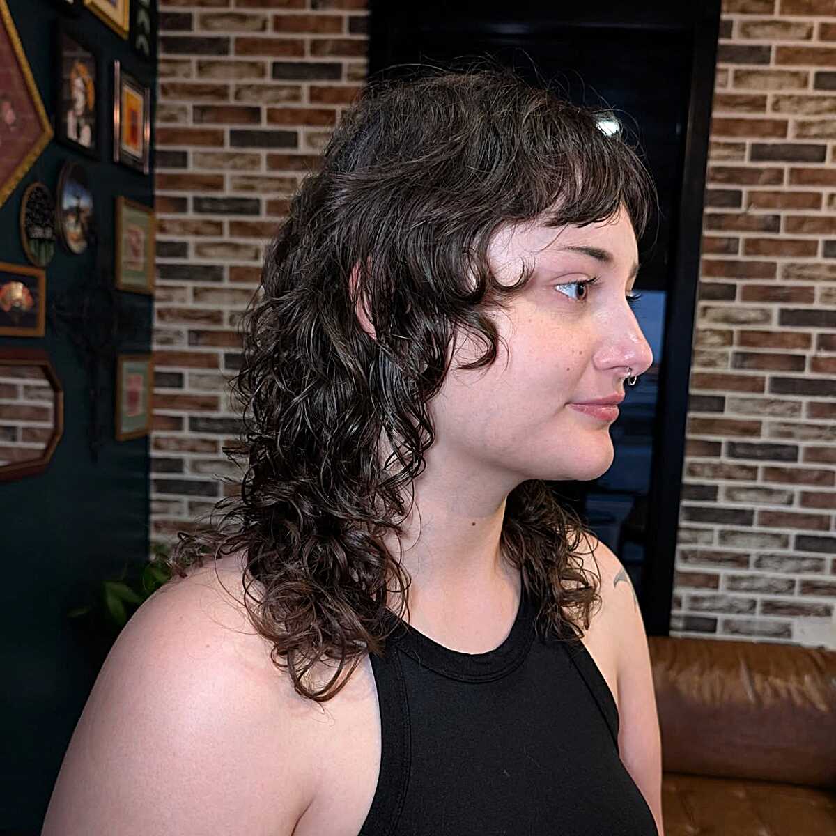 Dark curly mid-length shag with short bangs