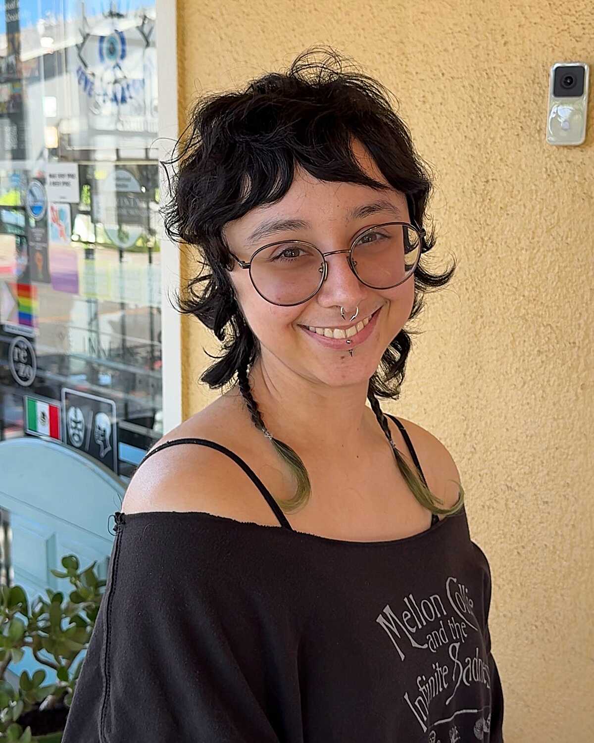 Short curly dark shag mullet with green-tipped ends