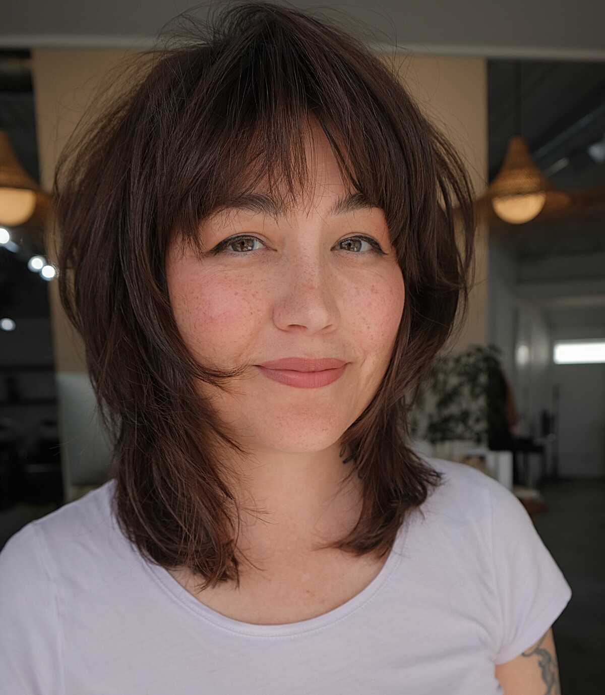 Short choppy brunette shag bob with wispy bangs