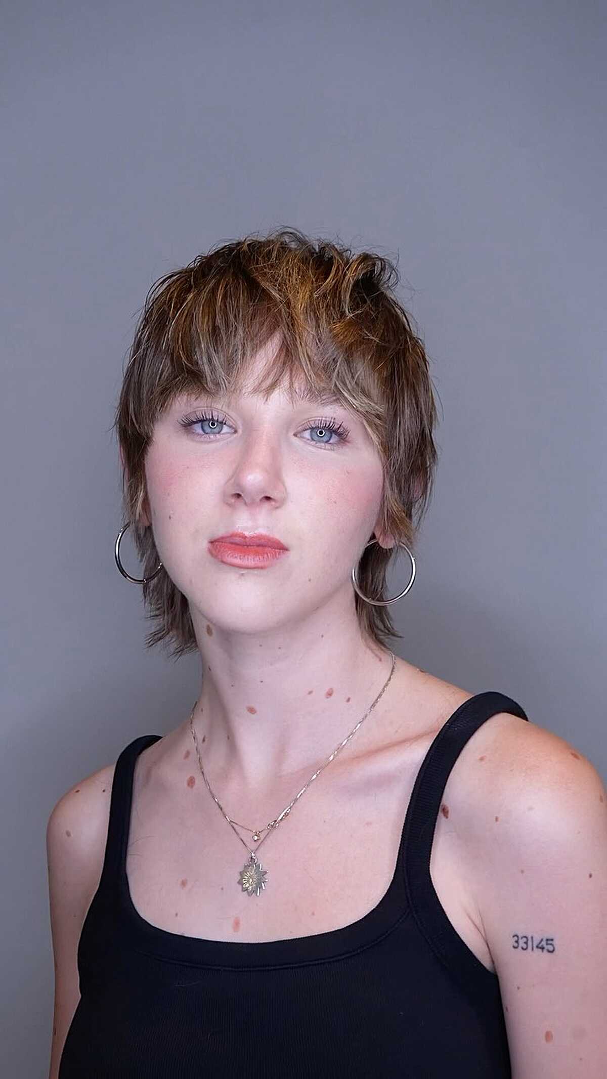 Short shaggy cut with golden highlights and wispy bangs