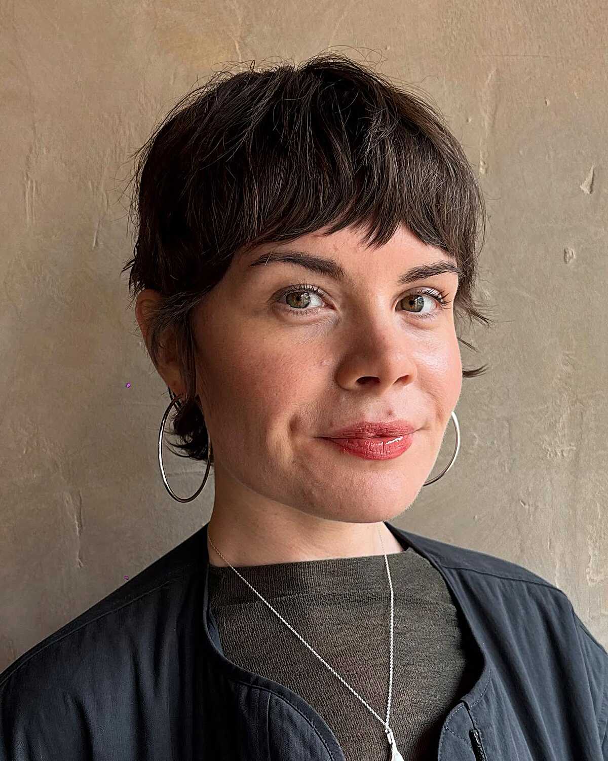 Short tousled dark brunette pixie with choppy bangs