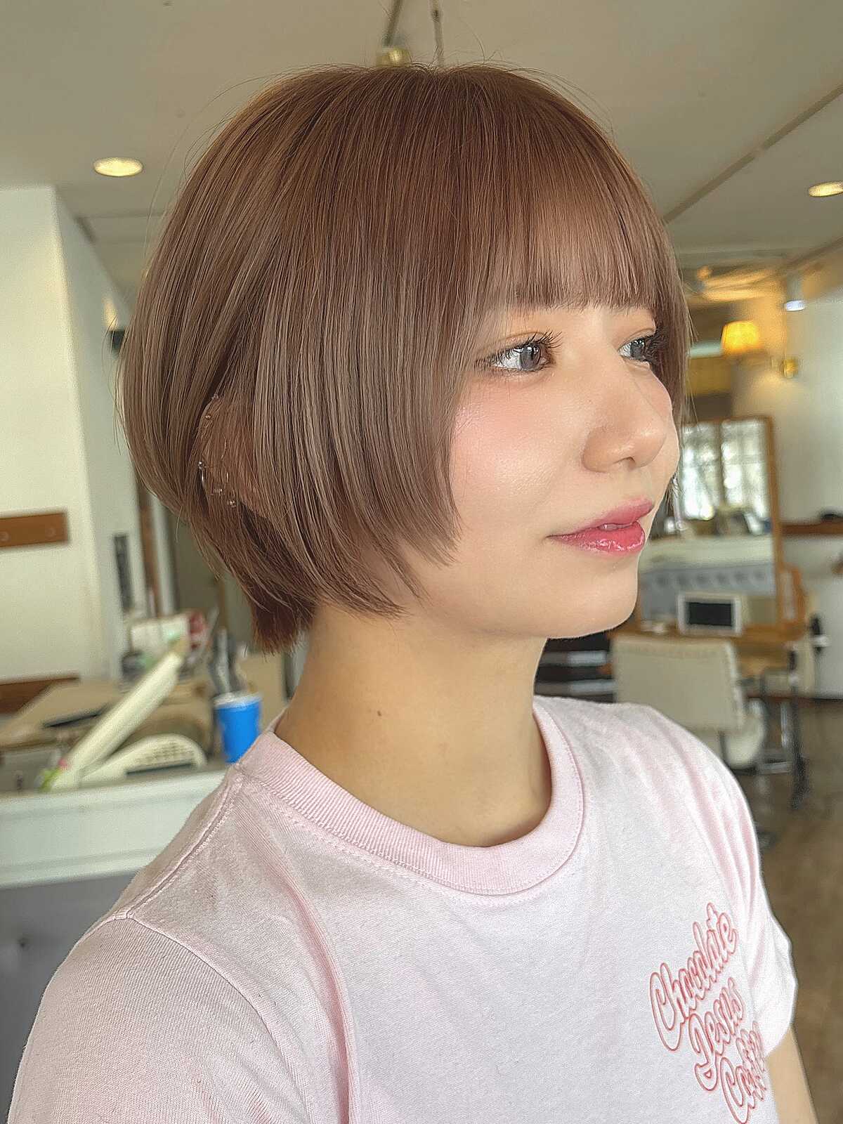 Warm copper chin-length rounded bob with soft bangs