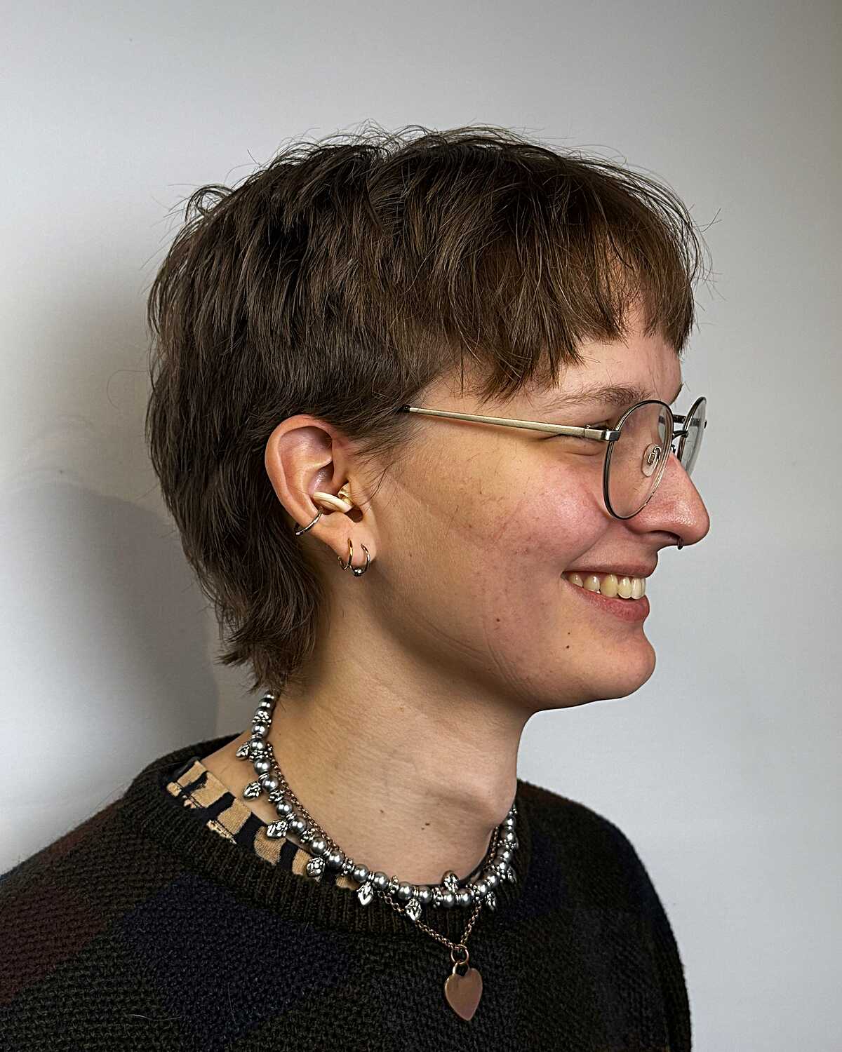 Short textured brown pixie mullet with wispy bangs