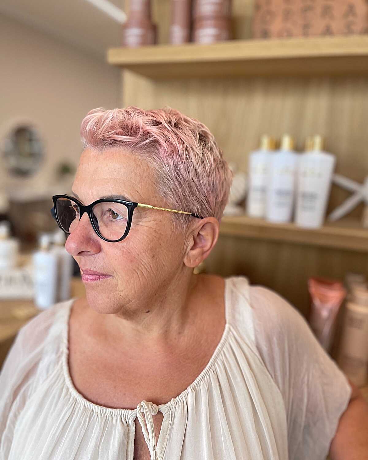 Pastel pink tousled pixie cut on older woman