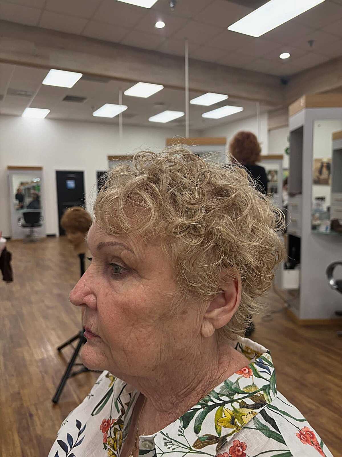 Short golden blonde curly pixie on older woman