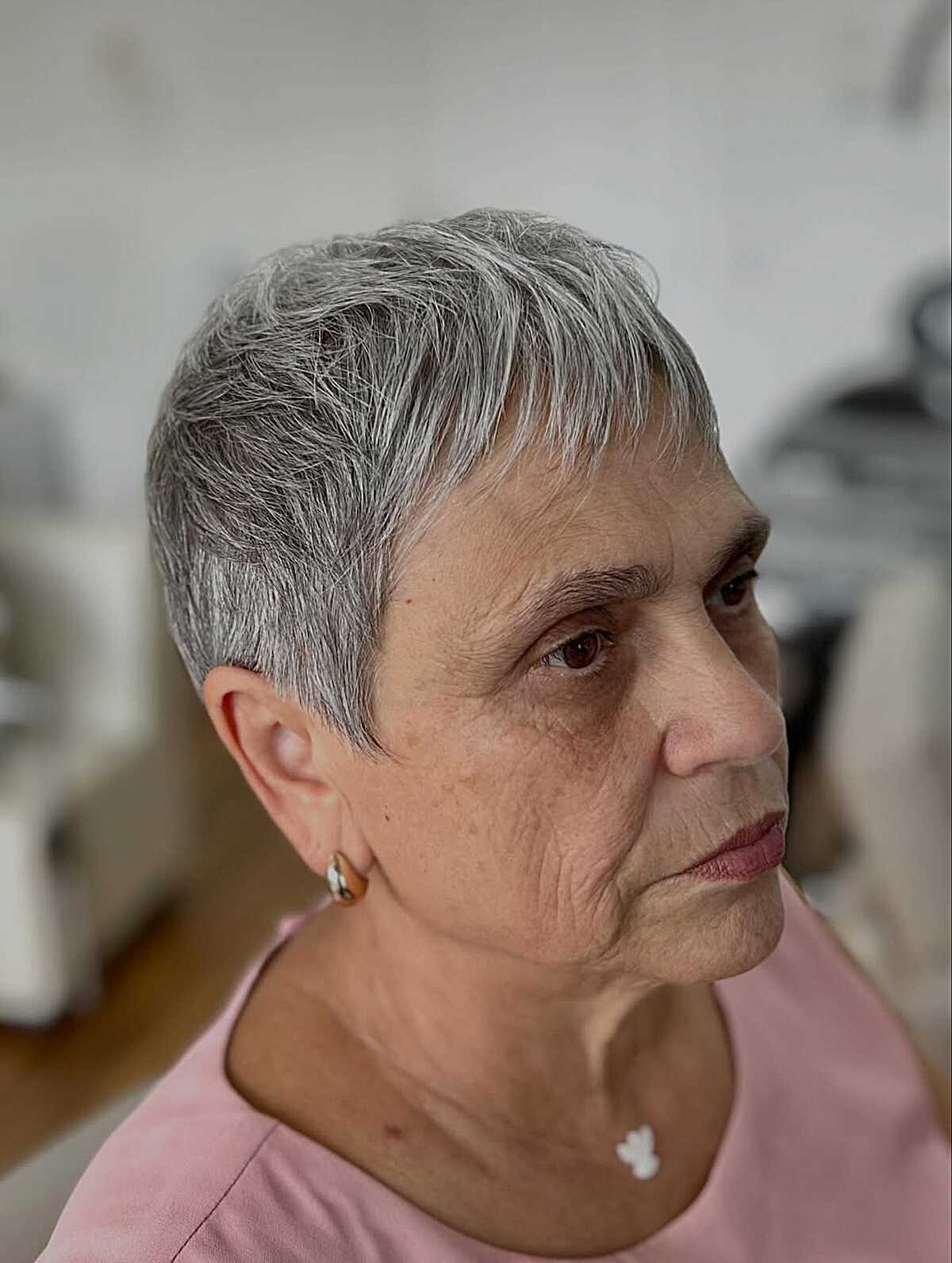 Short silver pixie with tapered sides on older woman