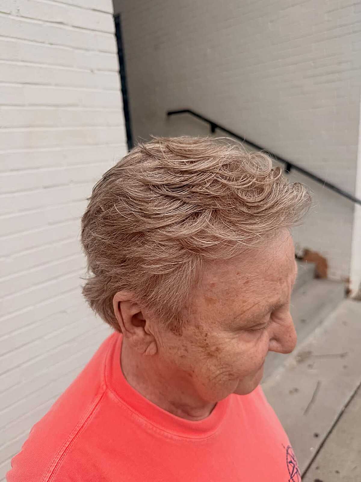 Wavy ash blonde tousled pixie on older woman
