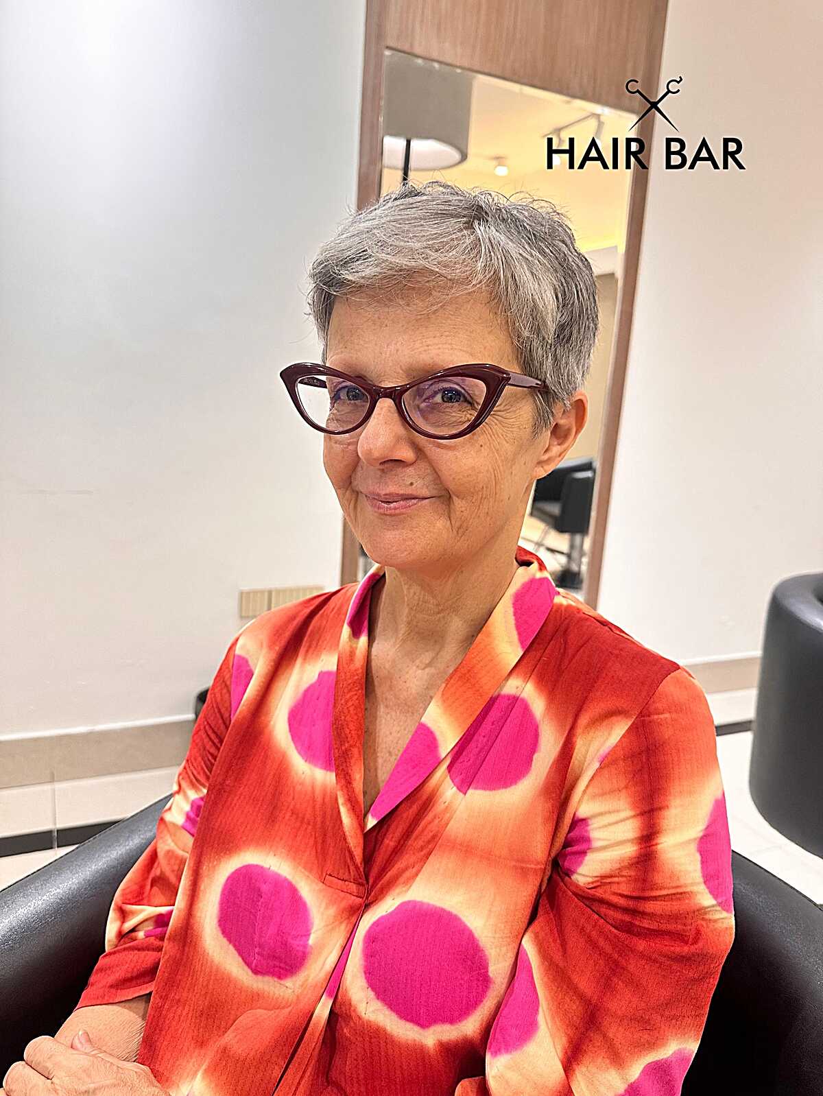 Very short wispy gray pixie with cat-eye glasses