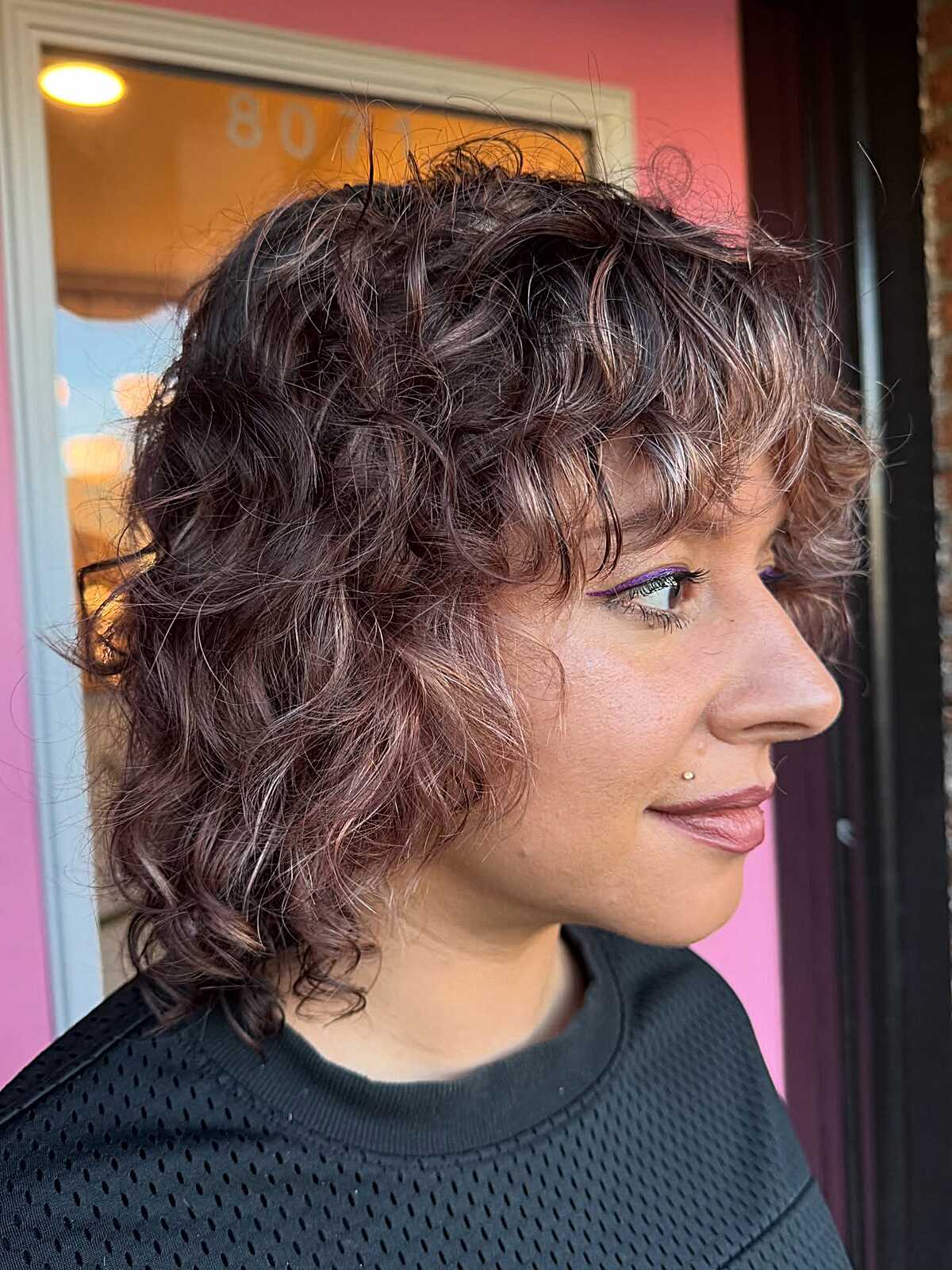 Curly plum brown bob shag with highlights side view