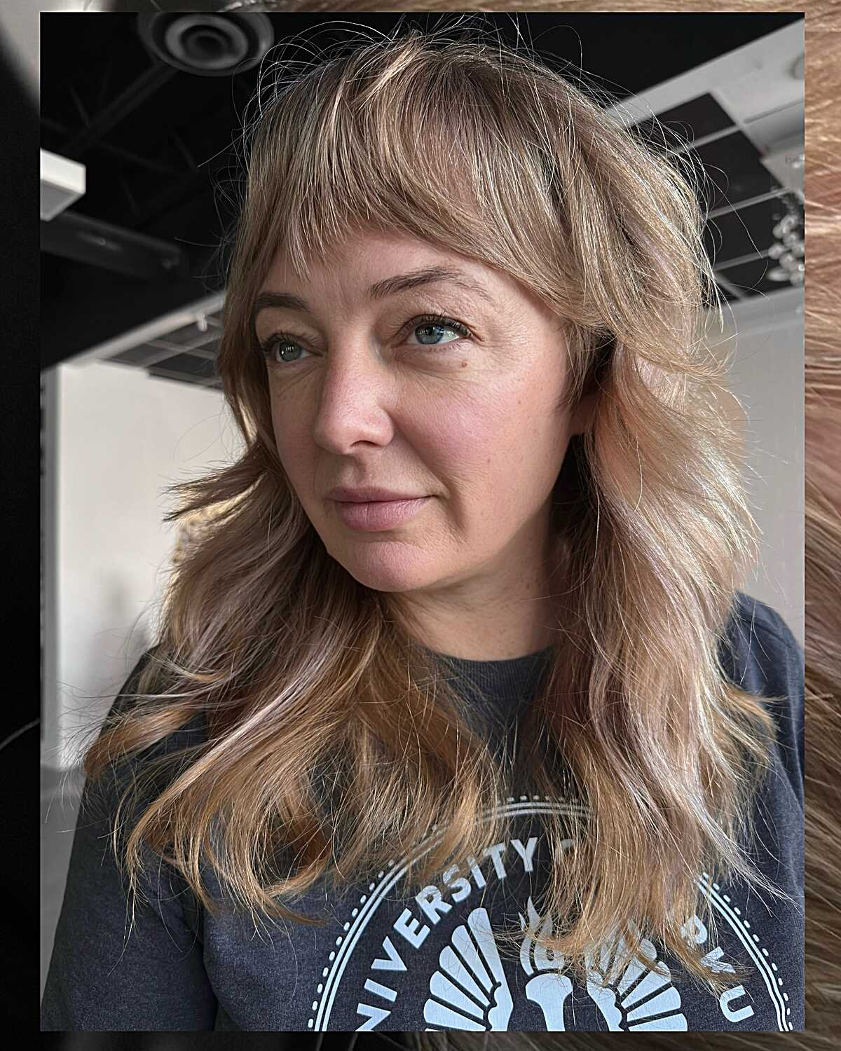 Long sandy blonde feathered shag with wispy bangs