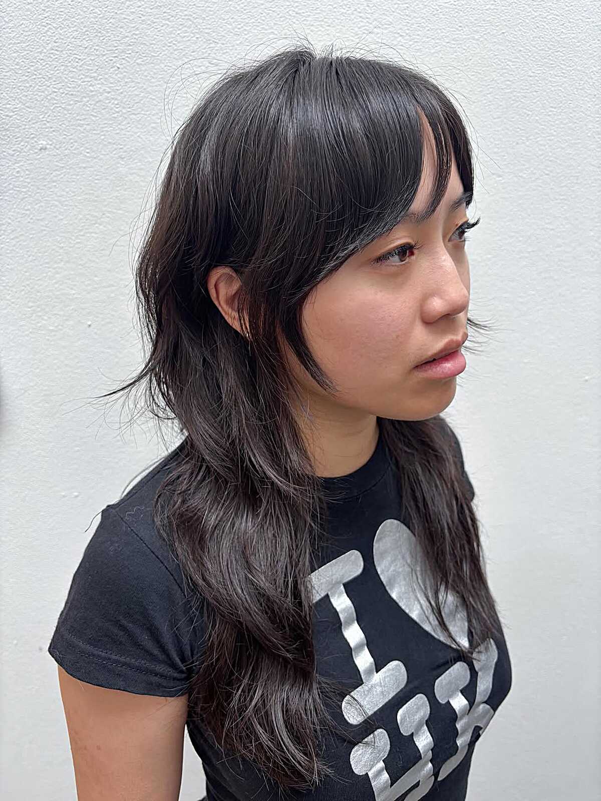 Long dark sleek shag with curtain bangs side view